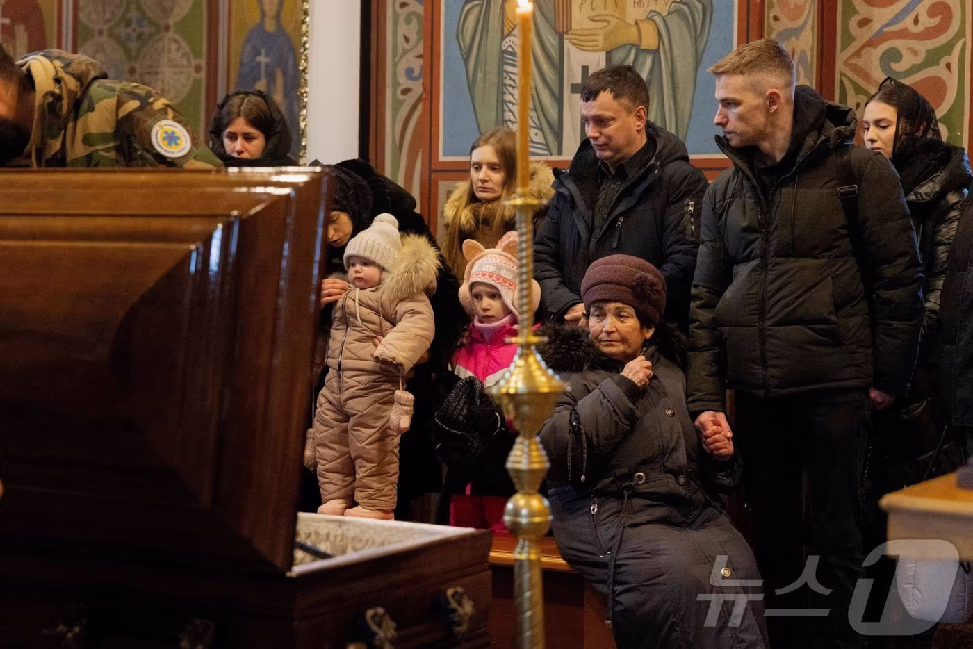 12일(현지시간) 우크라이나 키이우의 성 미하일 황금돔 수도원에서 열린 장례식에서 러시아 공격으로 사망한 의료진 세르기 스몰랴크의 관 앞에서 그의 유족과 지인들이 애도하고 있다. 2026.01.12 ⓒ AFP=뉴스1 ⓒ News1 김지완 기자