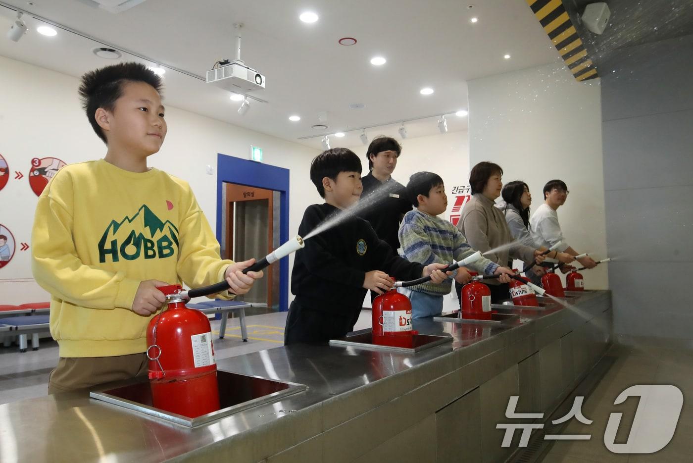 본문 이미지 - 13일 부산 강서구 부산시교육청 학생안전체험관에서 겨울방학을 맞아 '가족·일반인 안전체험'에 참가한 체험객들이 소화기를 이용해 화재 진화 체험을 하고 있다ⓒ 뉴스1 윤일지 기자