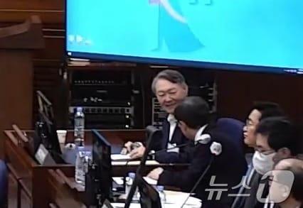 본문 이미지 - 윤석열 전 대통령이 13일 서울 서초구 서울중앙지방법원에서 열린 내란 우두머리 혐의 2차 결심공판에 출석해 변호인과 대화를 나누며 미소를 짓고 있다. (서울중앙지방법원 제공 영상 캡쳐. 재판매 및 DB 금지) 2026.1.13/뉴스1