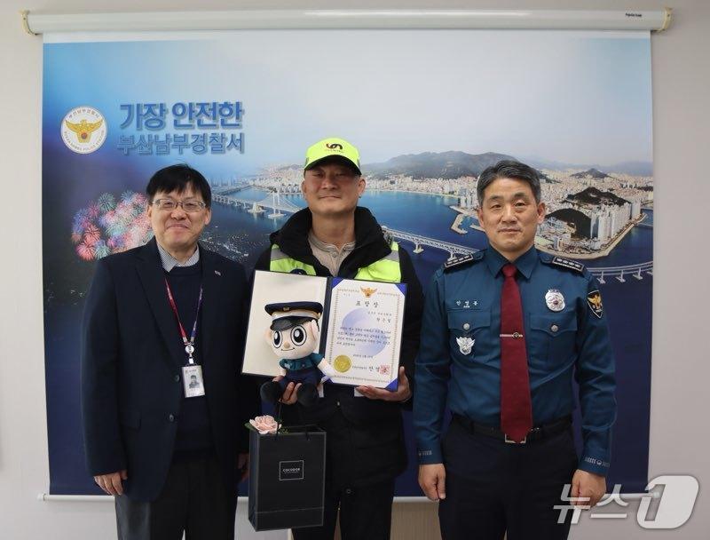 본문 이미지 - 부산 남구청 소속 환경관리원 황은철 씨가 분실물을 찾아준 공로로 13일 부산남부경찰서로부터 감사장을 받고 기념 촬영하고 있다.(부산 남구청 제공. 재판매 및 DB금지)
