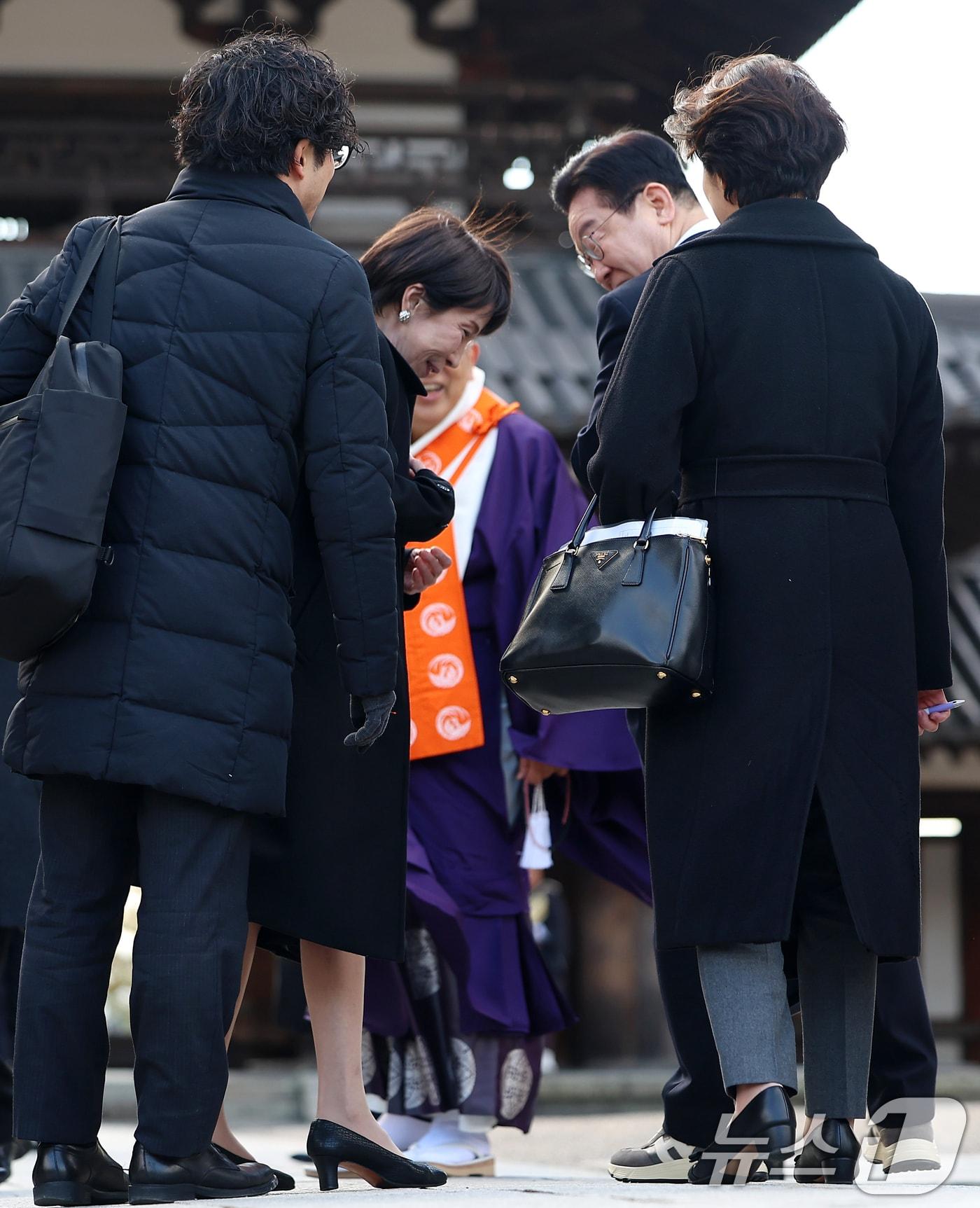 본문 이미지 - 이재명 대통령과 다카이치 사나에 일본 총리가 14일 일본 나라현 호류지에서 기념촬영을 마친 뒤 이 대통령이 착용한 운동화에 대해 이야기를 하고 있다. 2026.1.14/뉴스1 ⓒ News1 이재명 기자