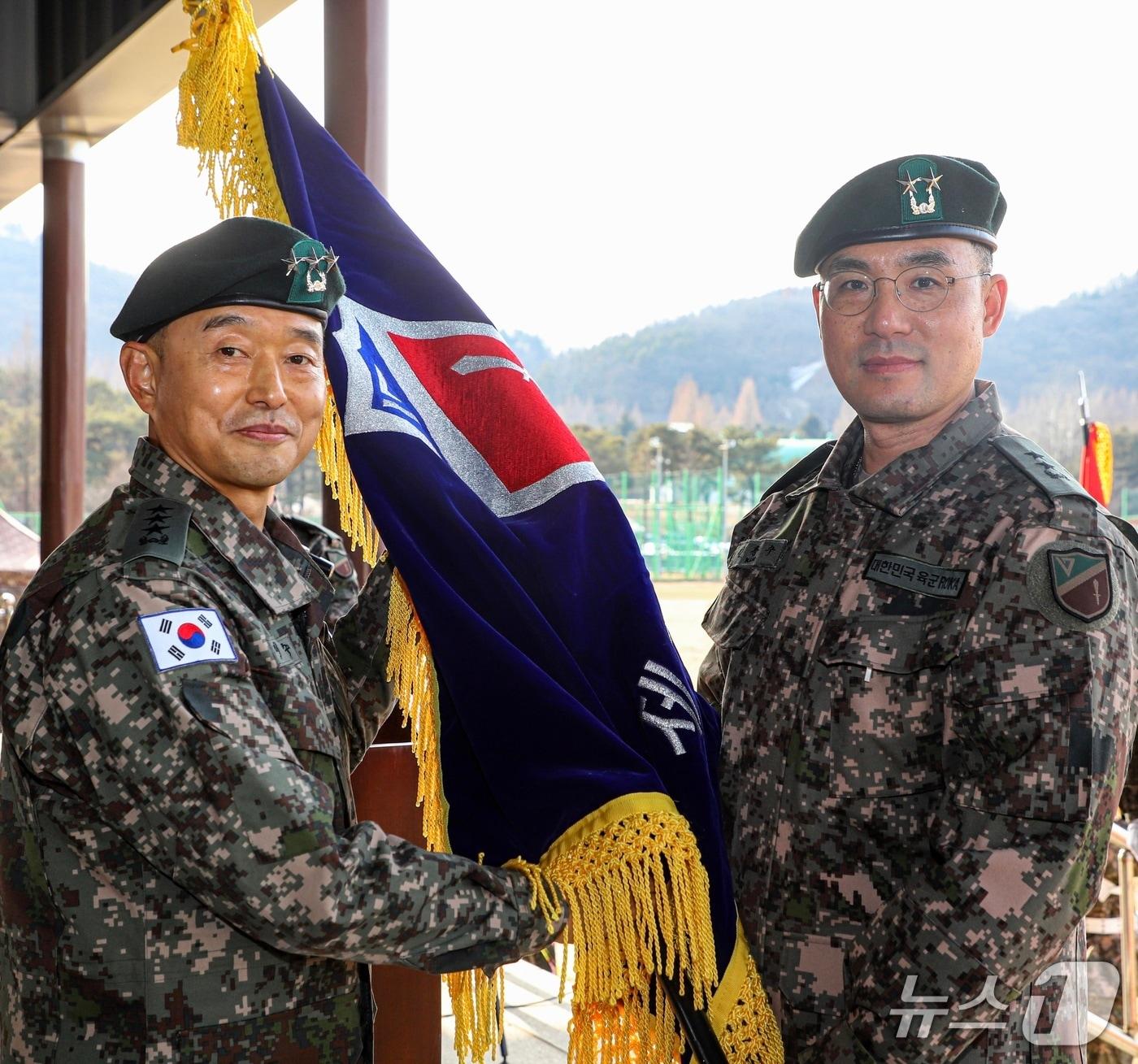본문 이미지 -  김용수 소장(사진 오른쪽)이 이임수 육군 수도군단장으로부터 17사단 부대기를 이양받고 있다(육군 17사단 제공/뉴스1)