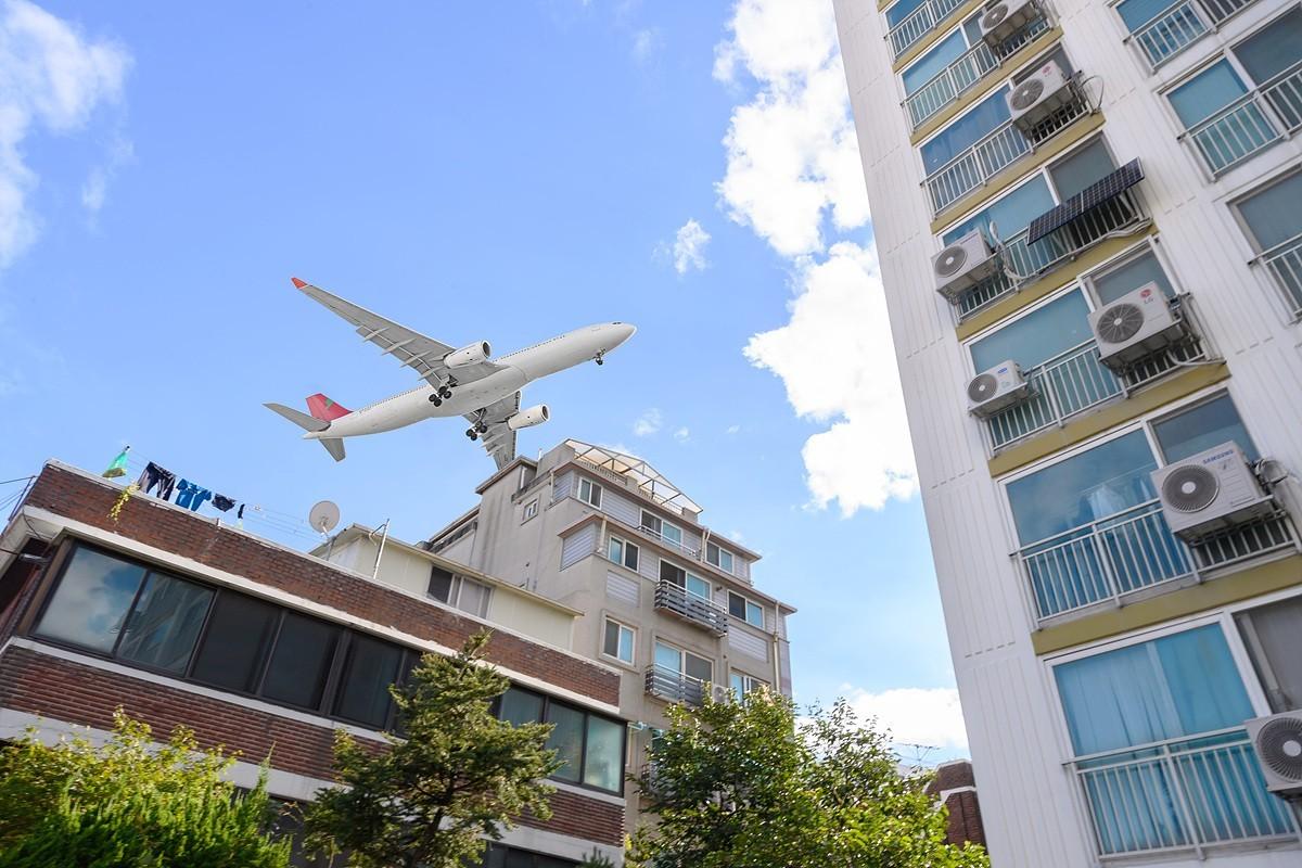 본문 이미지 - 공항소음피해지역 주택 위로 지나가는 항공기 모습(양천구 제공)