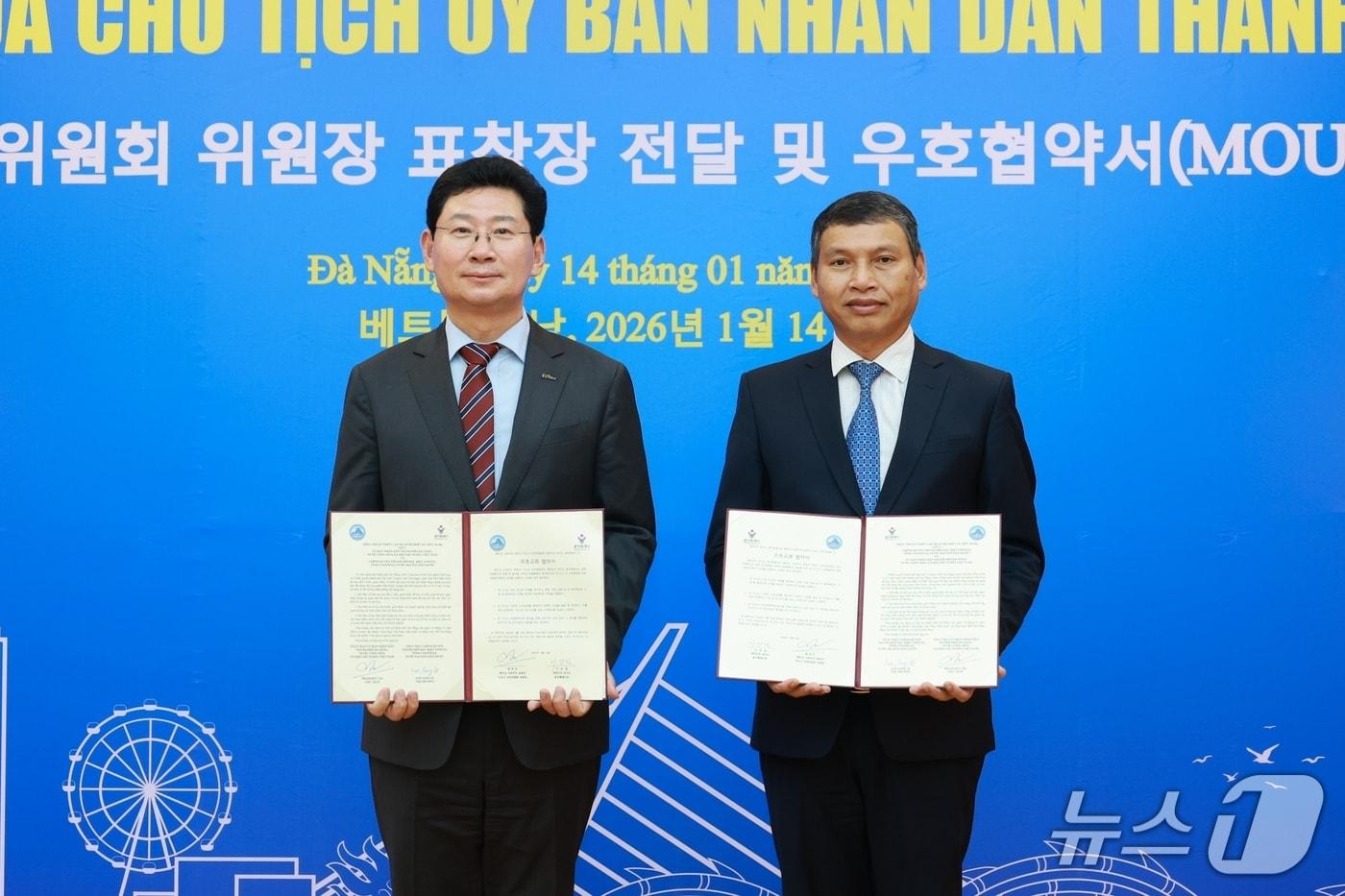 본문 이미지 - 이상일 용인시장(왼쪽)은 14일(현지시간) 베트남 다낭 시청에서 호 끼 민 다낭시 상임 부인민위원장과 우호협약을 체결했다.(용인시 제공)