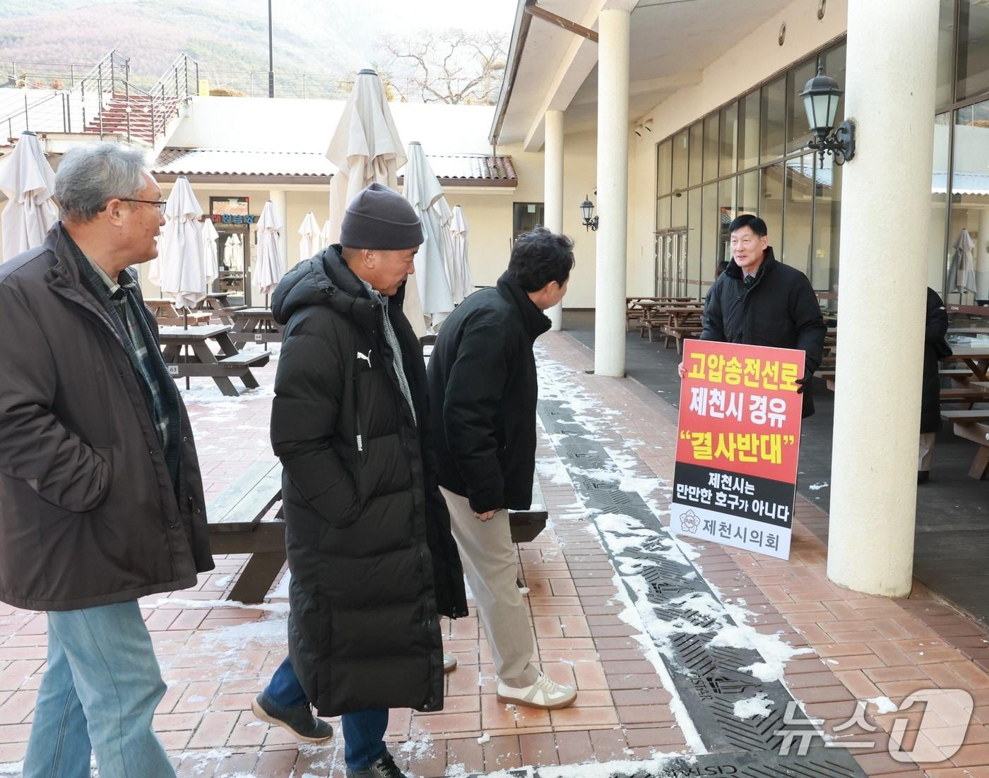 본문 이미지 - 박영기 제천시의회 의장(오른쪽)은 지난 14일 5차 회의장 입구에서 피켓을 들고 제천의 송전선로 재검토와 철회를 촉구했다.(제천시의회 제공. 재판매 및 DB금지) /뉴스1  