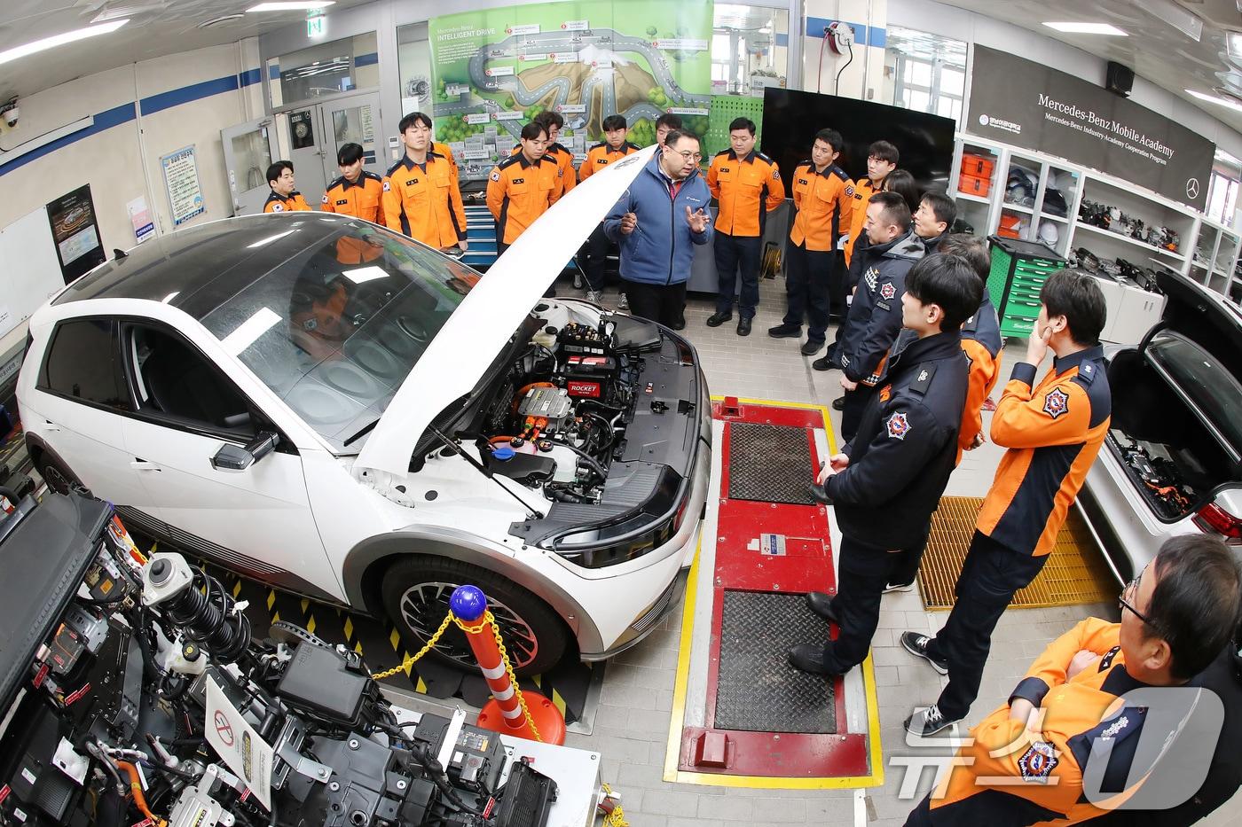 본문 이미지 - 영남이공대 스마트 e-자동차과 실습실에서 열린 '대구소방안전본부 전기자동차 화재진압 역량 강화 교육'에 참가한 소방관들이 전기차를 살펴보며 구동장치와 배터리 구조 등에 대한 설명을 듣고 있다. 2026.1.15/뉴스1 ⓒ News1 공정식 기자