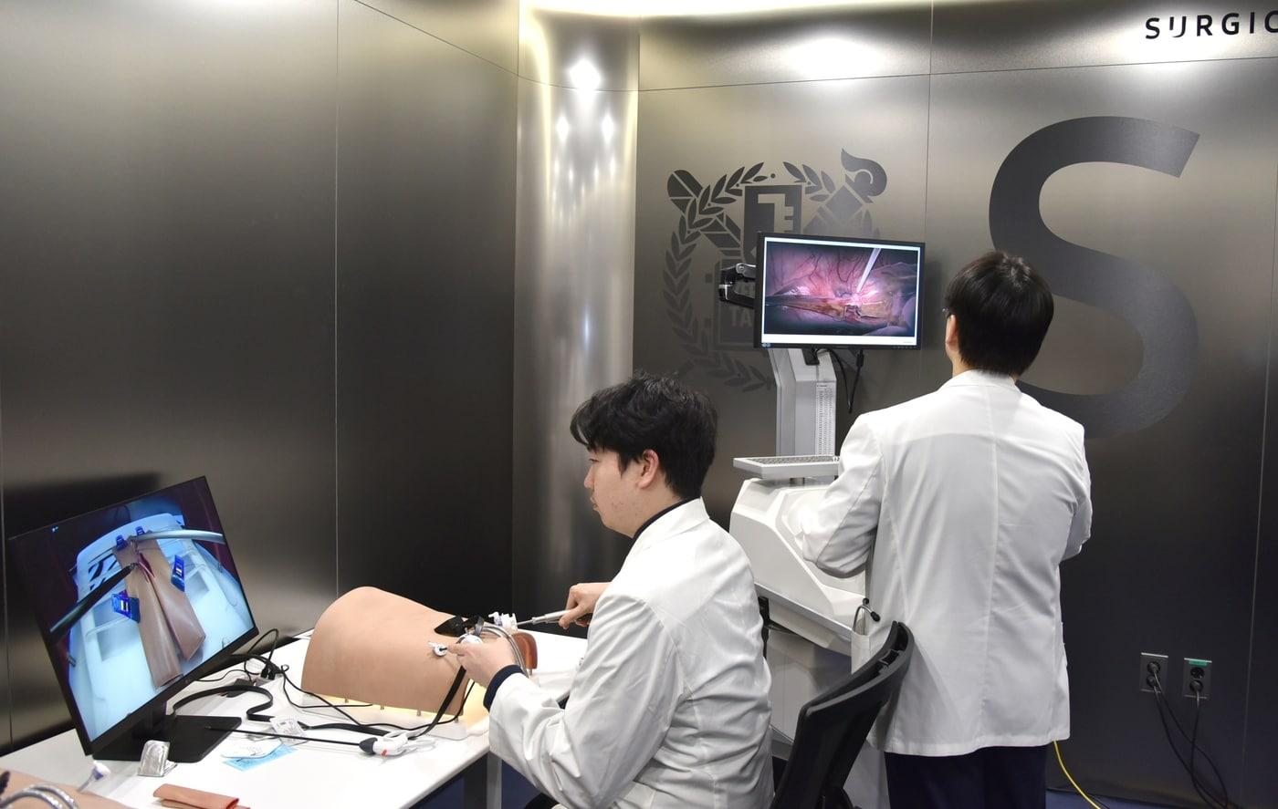 본문 이미지 - 서울대병원 외과 술기교육센터에서 교수진이 복강경 수술 시뮬레이터를 활용해 수술 술기를 시연하고 있다(서울대병원 제공)