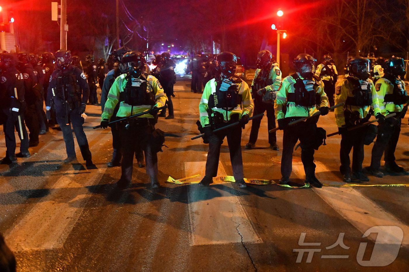 본문 이미지 - 14일(현지시간) 미네소타주 미니애폴리스에서 시위대가 연방 법집행관과 충돌한 뒤 주 경찰관들이 도로에 줄을 지어 섰다. 이날 시 당국은 이민세관단속국(ICE) 요원이 베네수엘라 출신 남성을 총격했다고 밝혔다. 당국은 일주일 전 같은 도시에서 요원이 미국 여성에게 총격을 가해 사망하게 한 사건이 있었던 만큼 시민들에게 “침착함을 유지해 달라”고 당부했다.2026.1.14. ⓒ AFP=뉴스1 ⓒ News1 권영미 기자