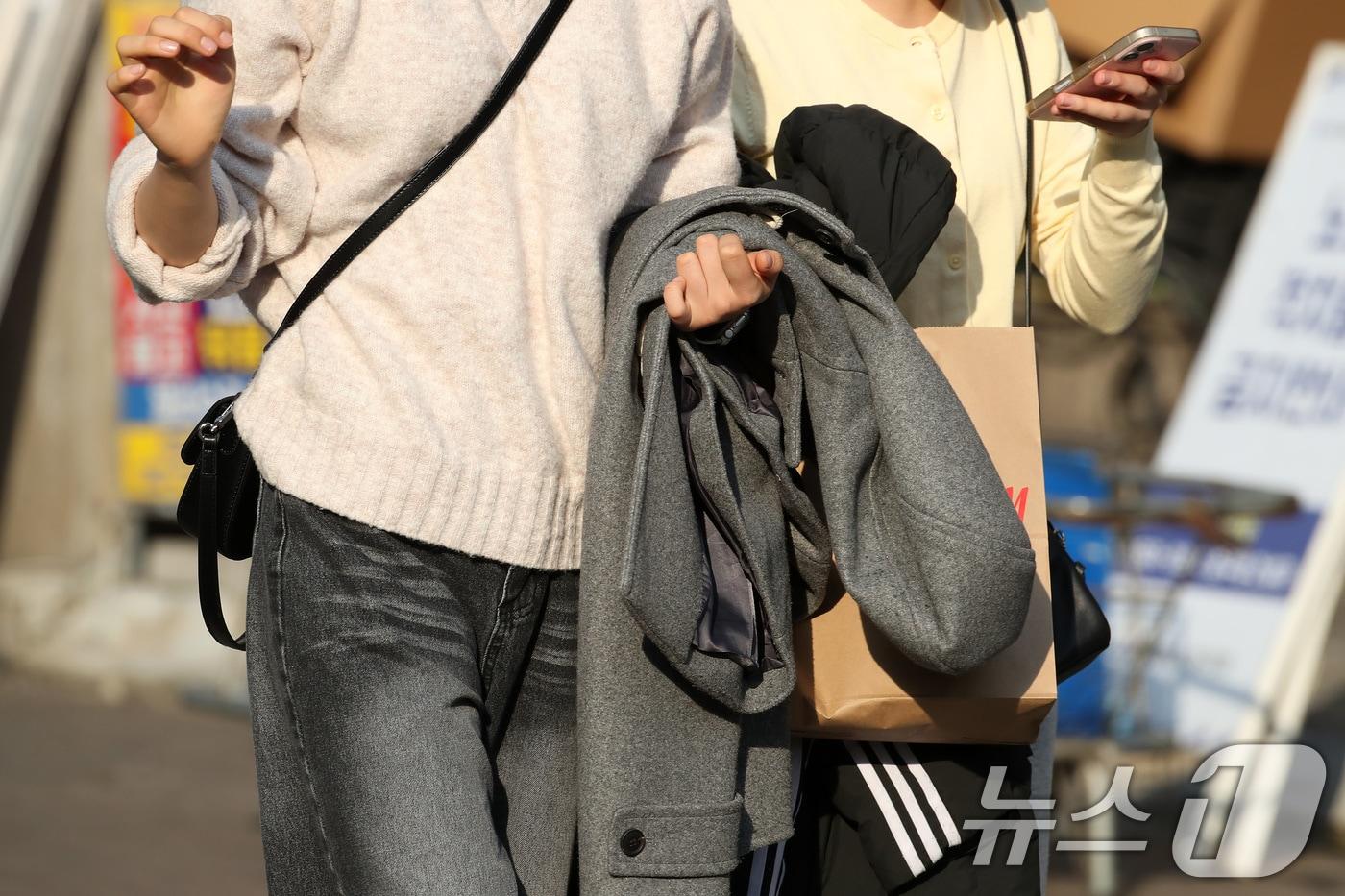 본문 이미지 - 하루 사이 기온이 크게 오른 15일 오후 대구 중구 동성로에서 외투를 벗어 손에 든 시민들이 걸어가고 있다. 이날 대구의 낮 기온은 18도까지 치솟아 1월 기온으로는 관측 이래 최고를 기록했다.2026.1.15/뉴스1 ⓒ News1 공정식 기자