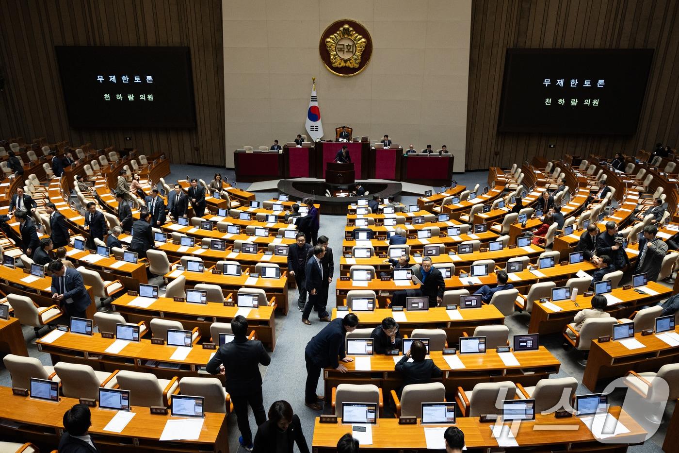 본문 이미지 - 15일 서울 여의도 국회에서 열린 제431회 국회(임시회) 제1차 본회의에서 윤석열·김건희에 의한 내란·외환 및 국정농단 행위의 진상규명을 위한 특별검사 임명 등에 관한 법률안에 대한 천하람 개혁신당 원내대표의 무제한 토론(필리버스터)이 시작되자 여야 의원들이 본회의장을 빠져나가고 있다. 2026.1.15/뉴스1 ⓒ News1 유승관 기자