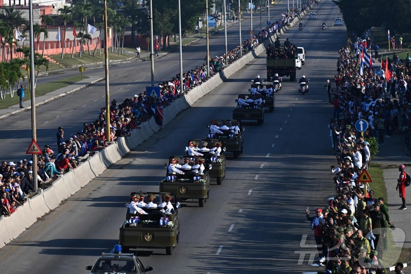 본문 이미지 - 15일(현지시간) 쿠바 시민들이 니콜라스 마두로 베네수엘라 대통령 체포 작전 중 사망한 쿠바 군인 32명의 유해를 운구하는 장례 행렬에 작별 인사를 하고 있다. 2026.01.15. ⓒ AFP=뉴스1