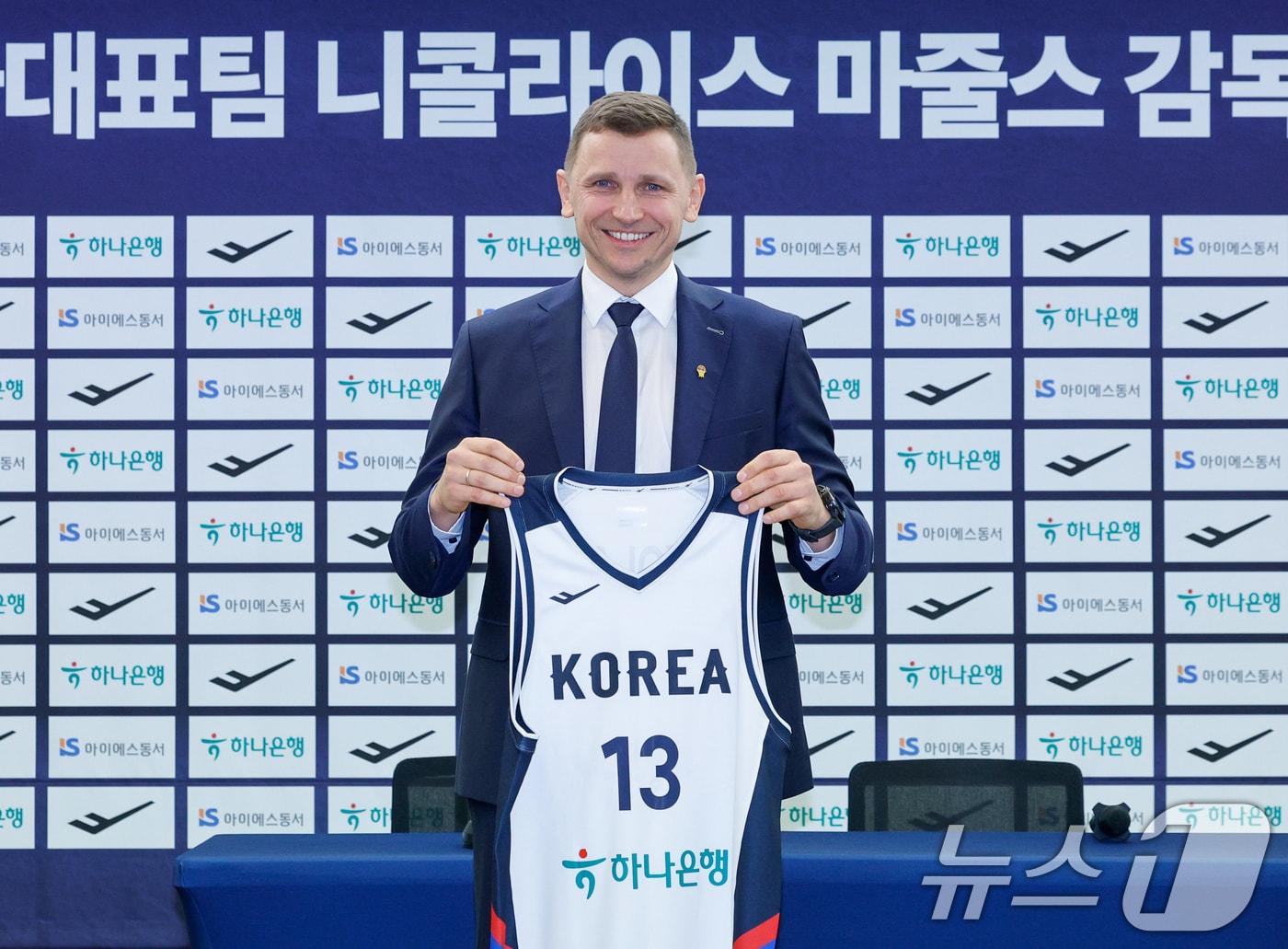 본문 이미지 - 남자 농구 국가대표팀을 이끌게 된 니콜라이스 마줄스(Nikolajs Mazurs) 감독이 16일 서울 중구 프레스센터에서 열린 취임 기자회견에서 유니폼을 들고 기념 촬영을 하고 있다. 2026.1.16 ⓒ 뉴스1 안은나 기자