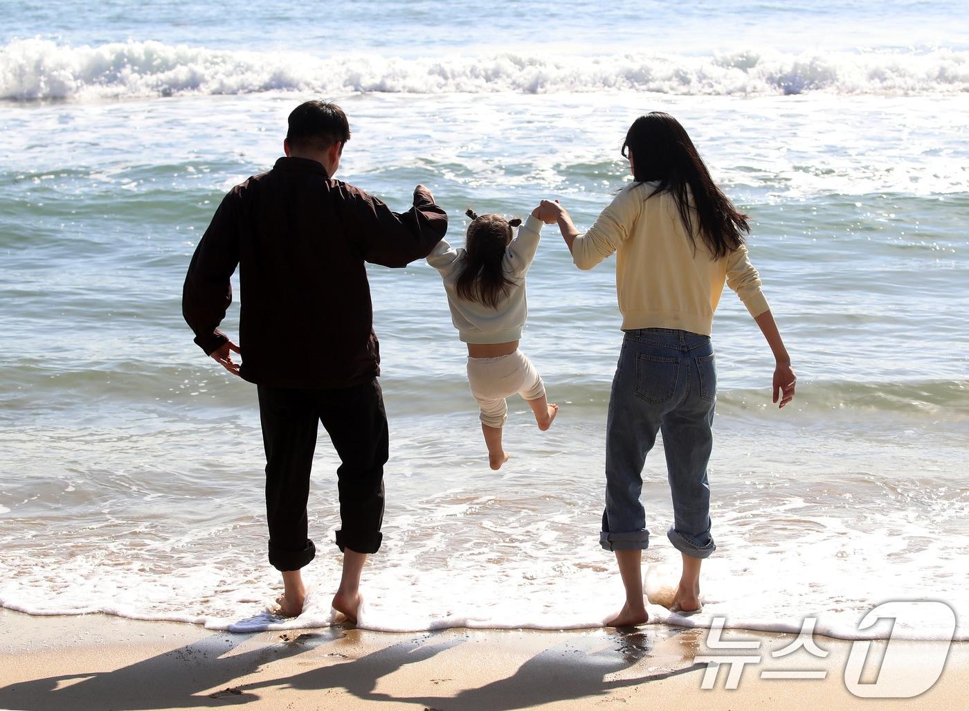 본문 이미지 - 포근한 날씨를 보인 16일 부산 해운대해수욕장에서 가벼운 복장 차림을 한 가족이 바닷물에 발을 담그며 즐거운 시간을 보내고 있다. 2026.1.16/뉴스1 ⓒ News1 윤일지 기자