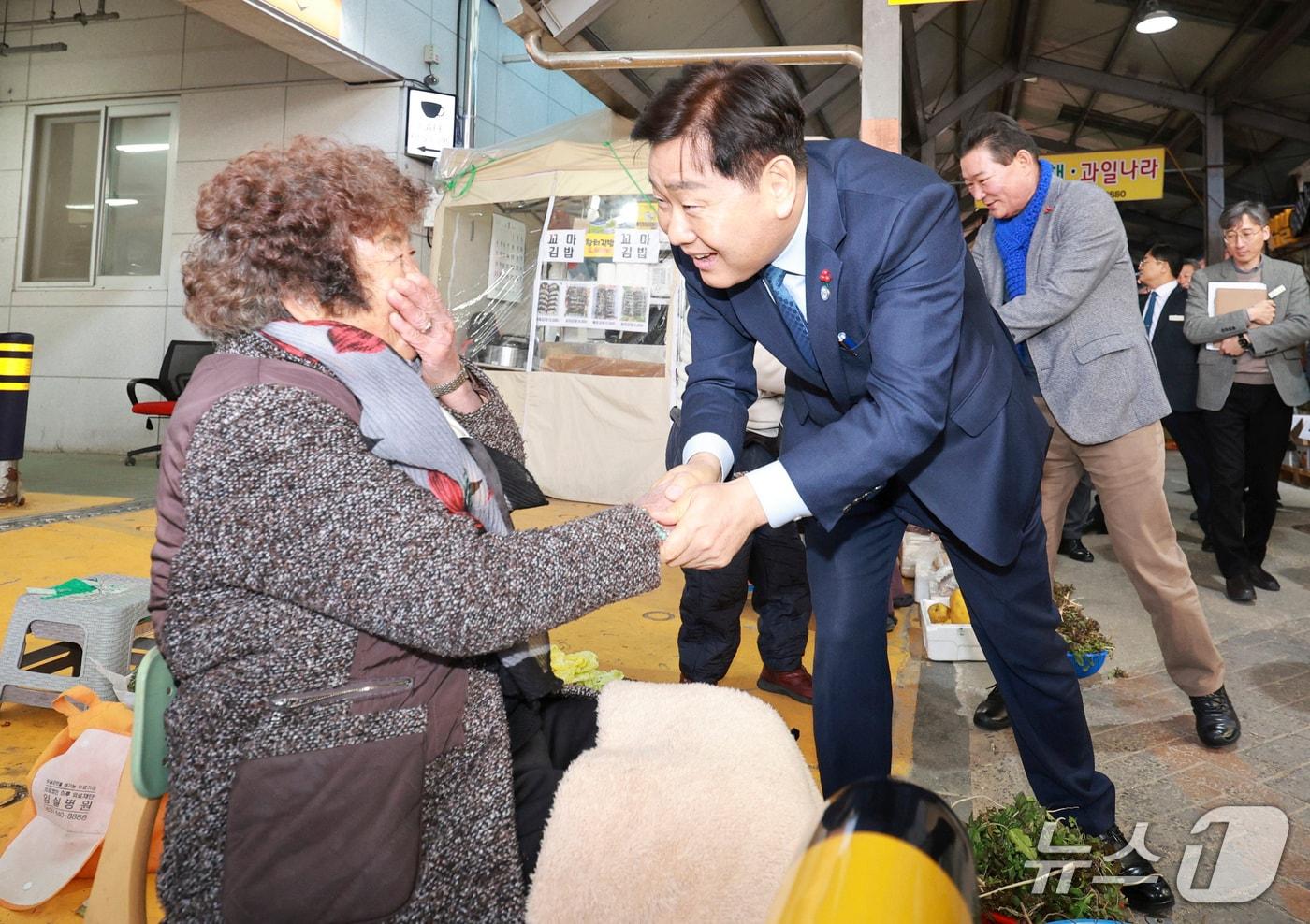 본문 이미지 - 16일 '도민과 함께하는 2026년 시군 방문' 행사를 위해 전북 임실군을 방문한 김관영 도지사가 전통시장에서 한 상인과 손을 잡고 이야기를 나누고 있다.(전북도 제공. 재판매 및 DB금지)/뉴스1