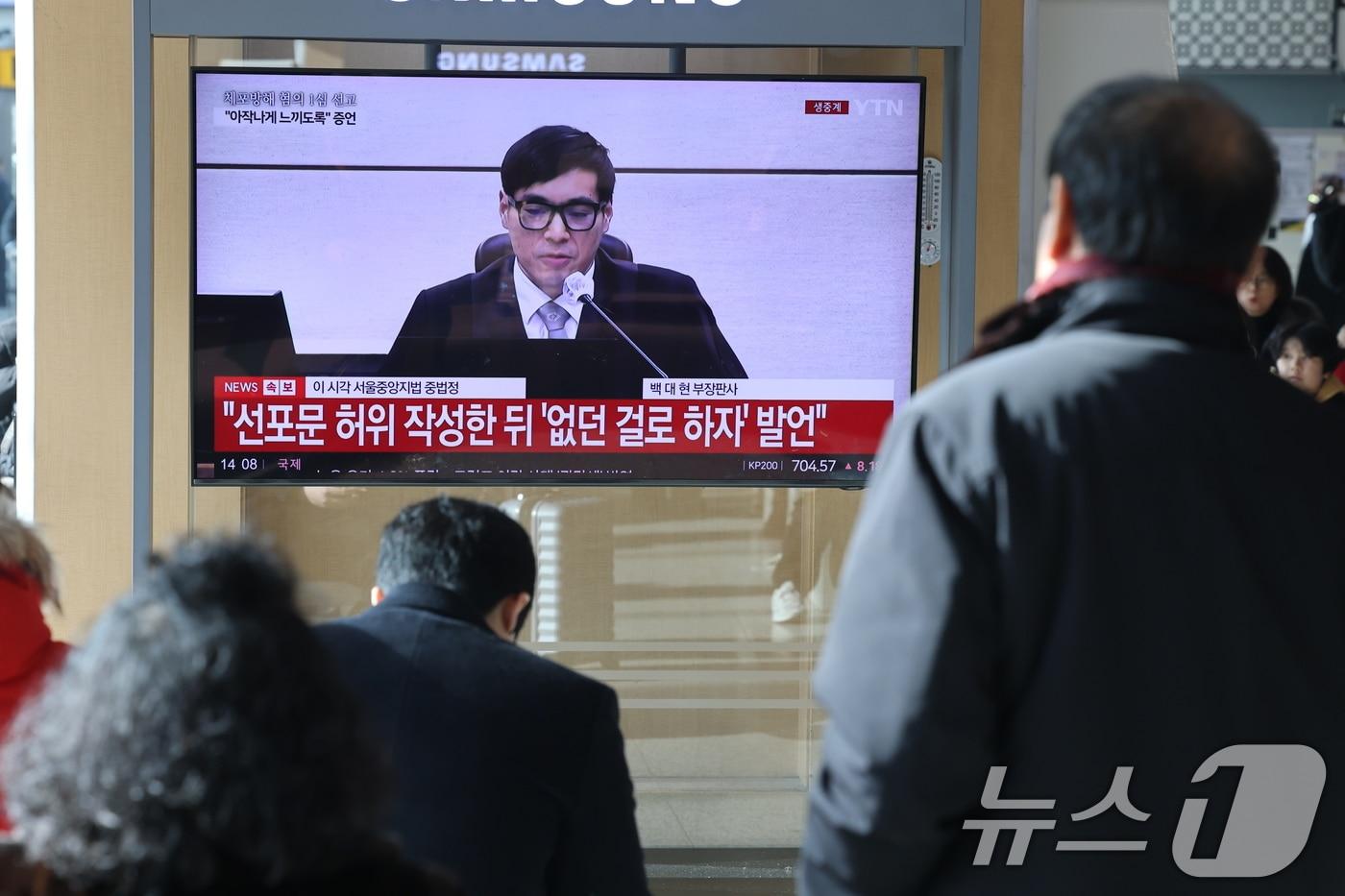 본문 이미지 - 16일 오후 서울역에서 시민들이 체포 방해와 국무위원 심의권 침해 등 혐의로 기소된 윤석열 전 대통령에 대한 1심 선고 생중계를 지켜보고 있다. 서울 서초구 중앙지방법원에서 열린 1심 선고에서 백대현 부장판사가 판결문을 낭독하는 모습. 2026.1.16/뉴스1 ⓒ News1 이광호 기자