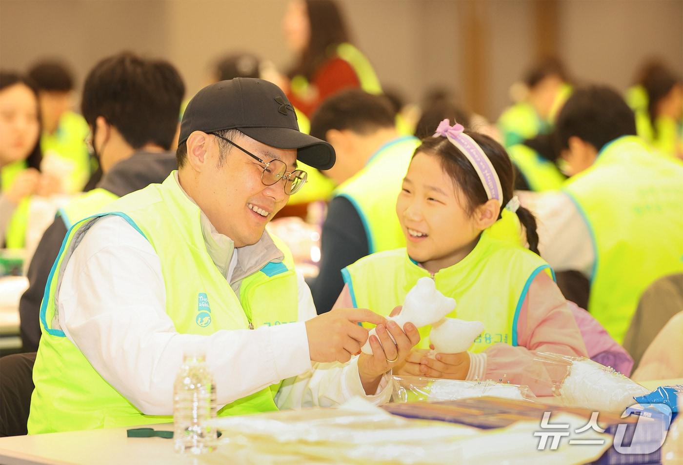 본문 이미지 - 하나금융그룹은 지난 17일 명동 사옥에서 2026년 새해를 맞아 미혼모 가정을 위한 '영유아 장난감 만들기' 임직원 봉사활동을 실시했다. 이날 봉사활동에 참여한 하나금융그룹 임직원 및 가족들이 정성껏 '영유아용 딸랑이'를 만들고 있다./사진제공=하나금융그룹