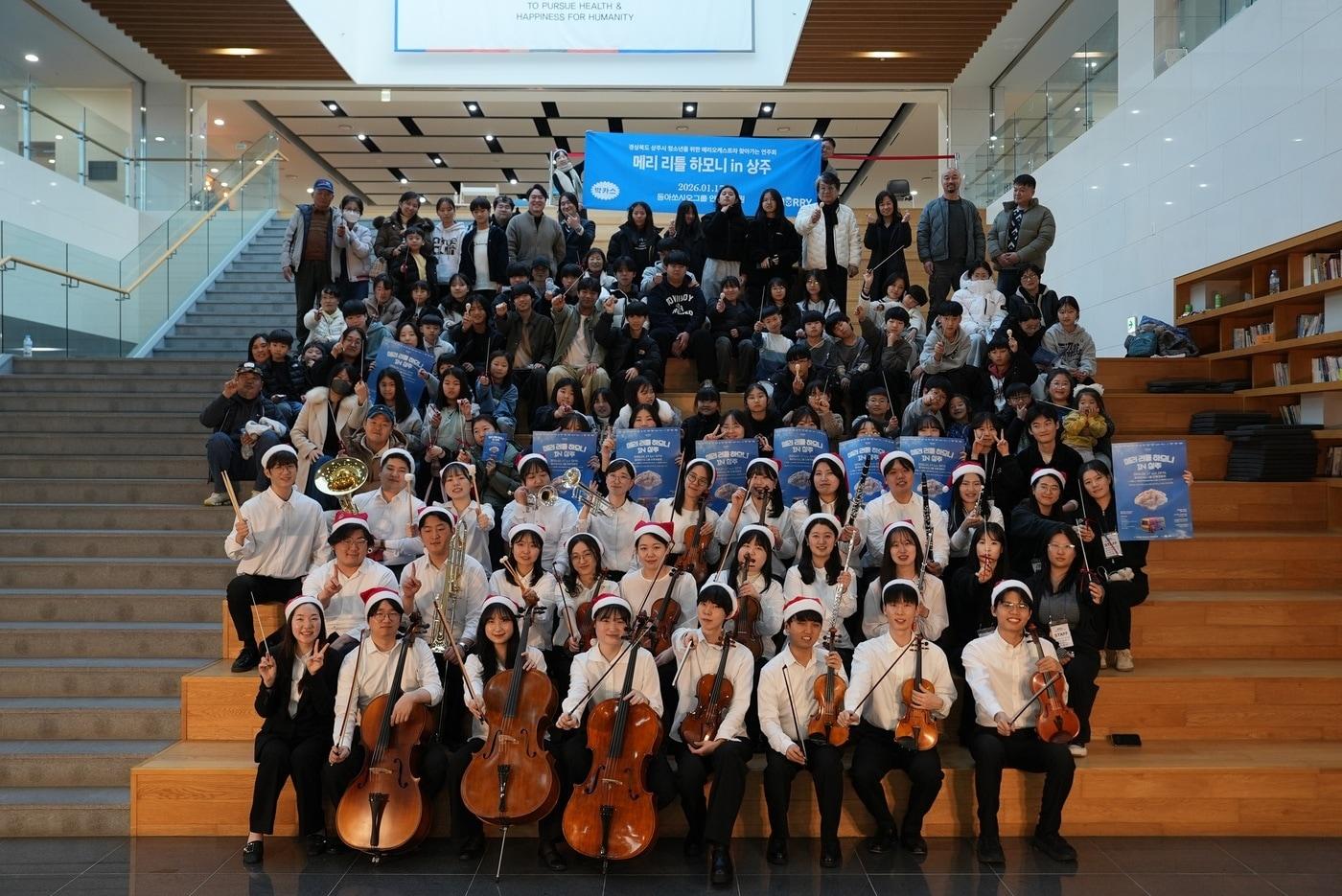 본문 이미지 - 지난 17일 경상북도 상주시에 위치한 동아쏘시오그룹 인재개발원에서 '메리 리틀 하모니' 연주단원과 관객들이 기념사진을 촬영하고 있다. /제공 = 동아제약