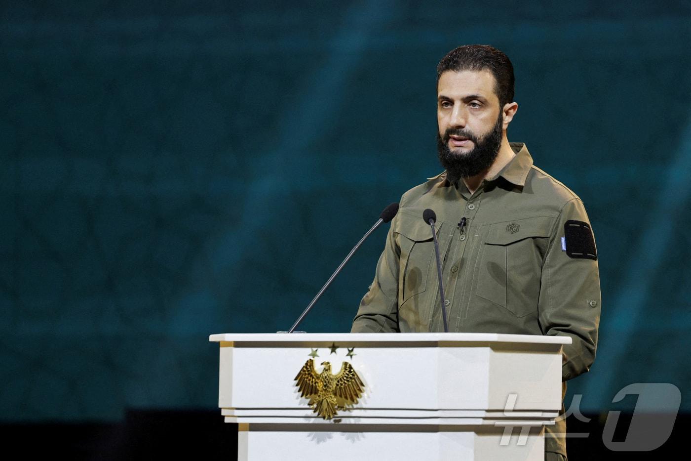 본문 이미지 - 아메드 알샤라 시리아 임시대통령이 지난해 12월 8일 다마스쿠스에서 바샤르 알 아사드 정권의 축출 1주년을 기념해 연설하고 있다. 2025.12.8 ⓒ 로이터=뉴스1 ⓒ News1 강민경 기자