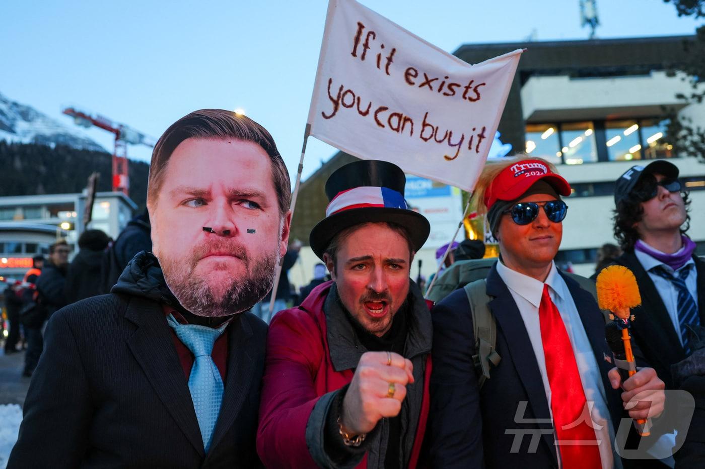 본문 이미지 - 18일(현지시간) 세계경제포럼(WEF) 연차총회(다보스포럼)가 개최될 예정인 스위스 다보스에서 시위대가 도널드 트럼프 미국 대통령의 분장을 하고 JD 밴스 미국 부통령의 가면을 쓴 모습. 2026.01.18 ⓒ 로이터=뉴스1 ⓒ News1 김지완 기자