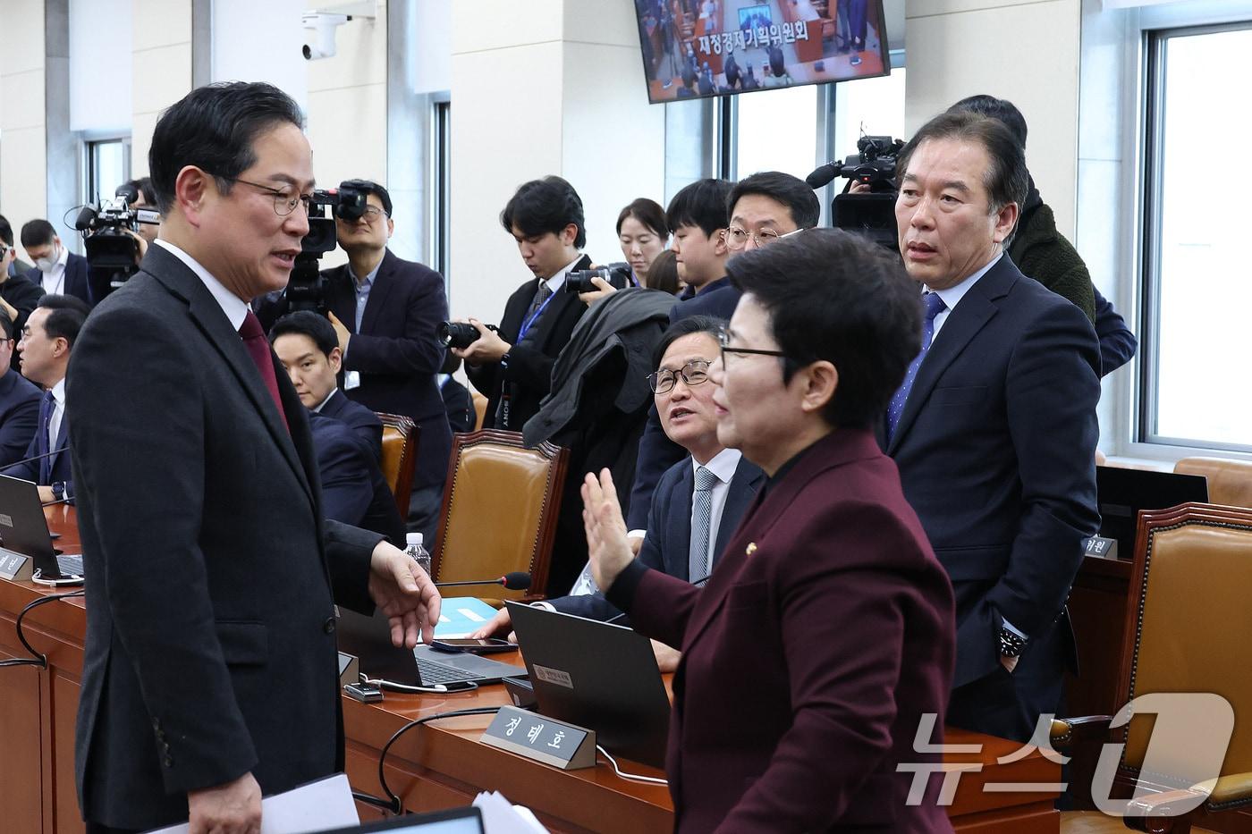 본문 이미지 - 임이자 위원장이 19일 서울 여의도 국회에서 열린 재정경제기획위원회가 정회된 후 정태호 더불어민주당 간사와 박수영 국민의힘 간사를 지나치고 있다. 2026.1.19/뉴스1 ⓒ News1 신웅수 기자