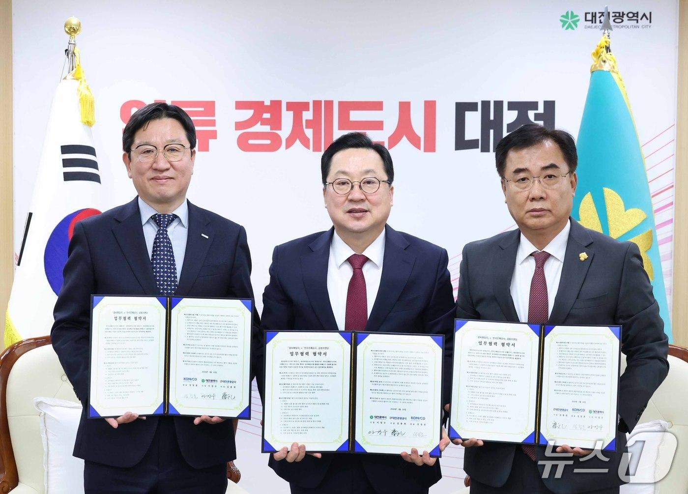 본문 이미지 - 성창훈 조폐공사 사장(왼쪽), 이장우 대전시장(가운데), 김용원 대전관광공사 사장이 협약서를 들고 기념 촬영하고있다. (한국조폐공사 제공.재판매 및 DB 금지)/뉴스1