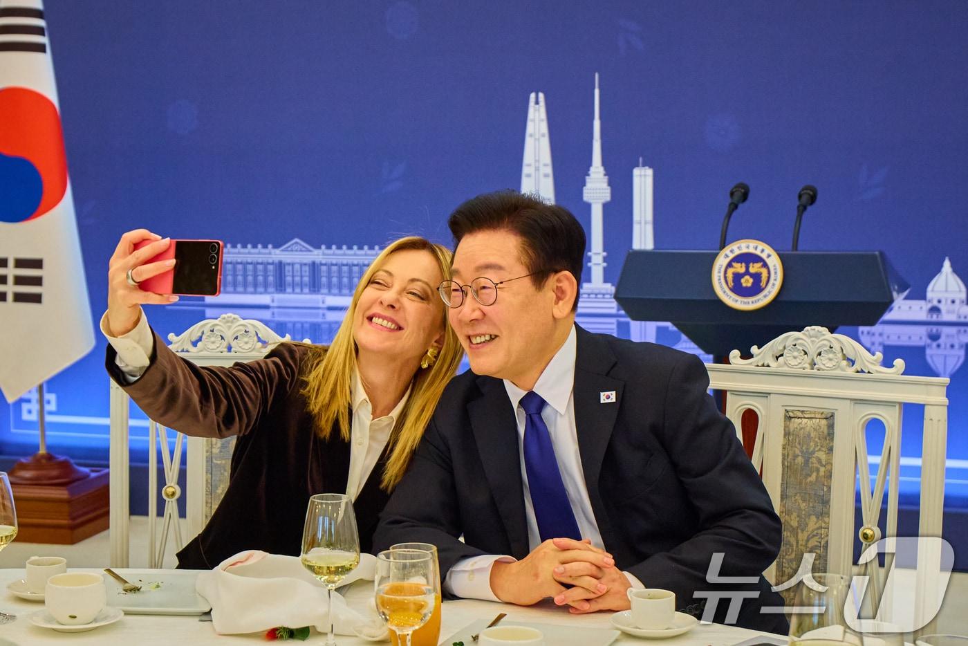 본문 이미지 - 이재명 대통령과 조르자 멜로니 이탈리아 총리가 19일 청와대에서 열린 공식 오찬에서 스마트폰으로 기념촬영을 하고 있다. 이 대통령은 이날 오찬 중 멜로니 총리께 삼성 갤럭시 Z플립7 스마트폰을 선물했다. (청와대 제공. 재판매 및 DB 금지) 2026.1.19/뉴스1 ⓒ News1 허경 기자