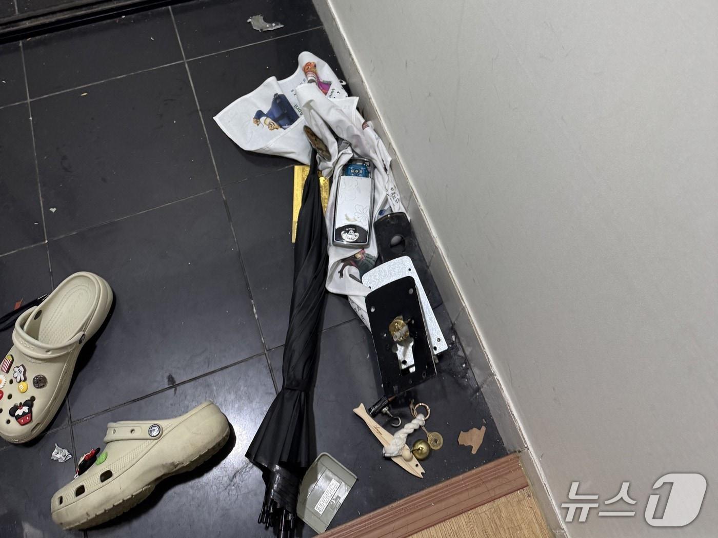 본문 이미지 - A 씨 집 현관문 앞 바닥에 도어락 건전지 등이 흩어진 채 놓여있다. (사진. 제보자 제공)