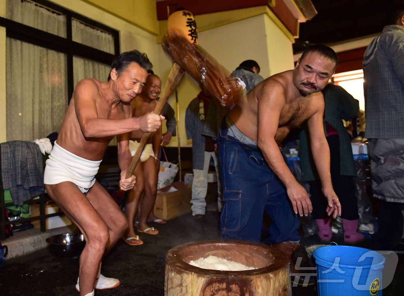 본문 이미지 - 일본 도쿄 칸다 신사에서 일본 남성들이 새해를 맞아 찐 쌀을 찧어 모찌 떡을 만드는 행사가 열렸다.2016.01.01.ⓒ AFP=뉴스1<자료사진>