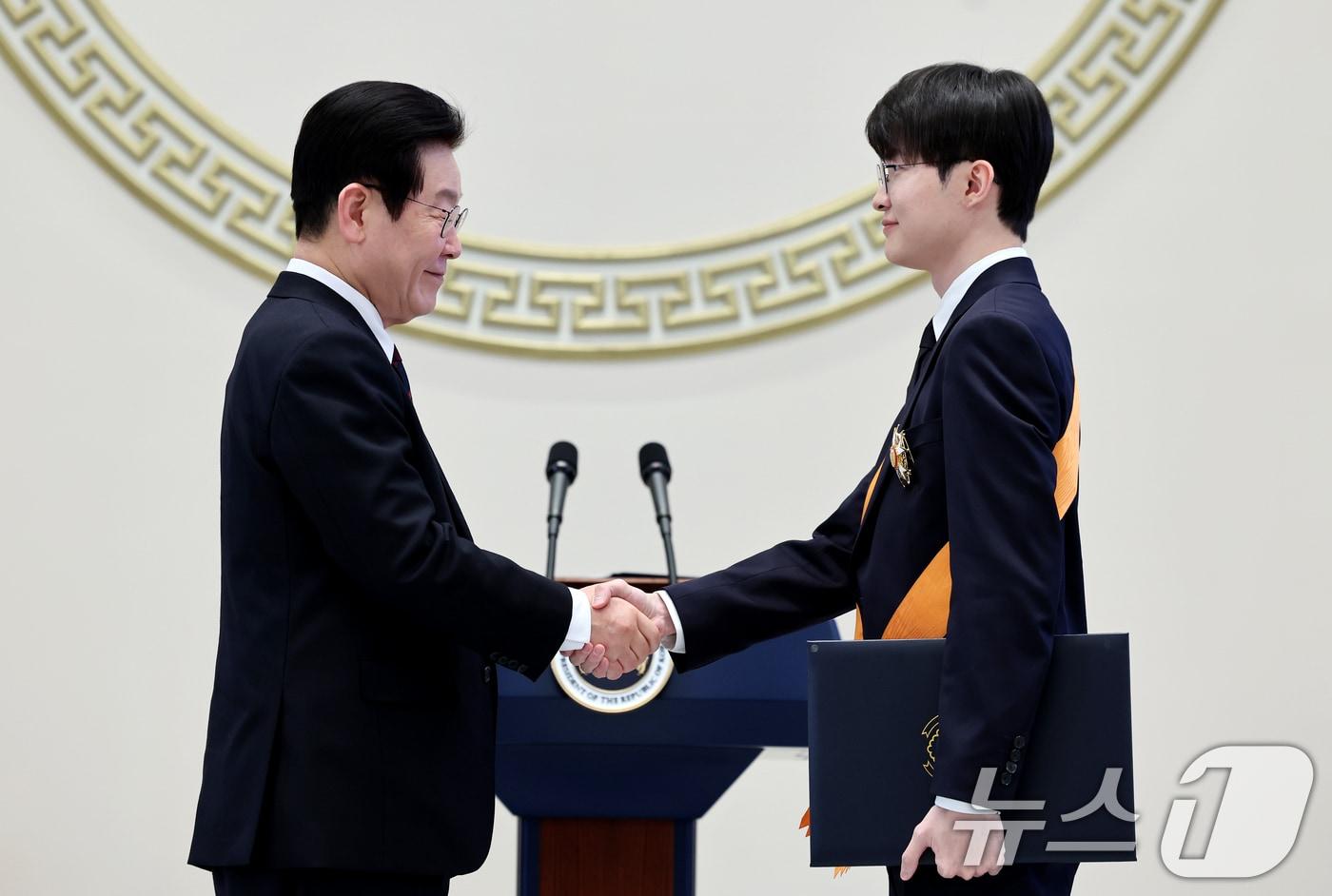 본문 이미지 - 이재명 대통령이 2일 청와대 영빈관에서 열린 2026년 신년 인사회에서 이상혁(페이커) 프로게이머에게 체육훈장 청룡장을 수여하고 있다. 2026.1.2 ⓒ 뉴스1 이재명 기자