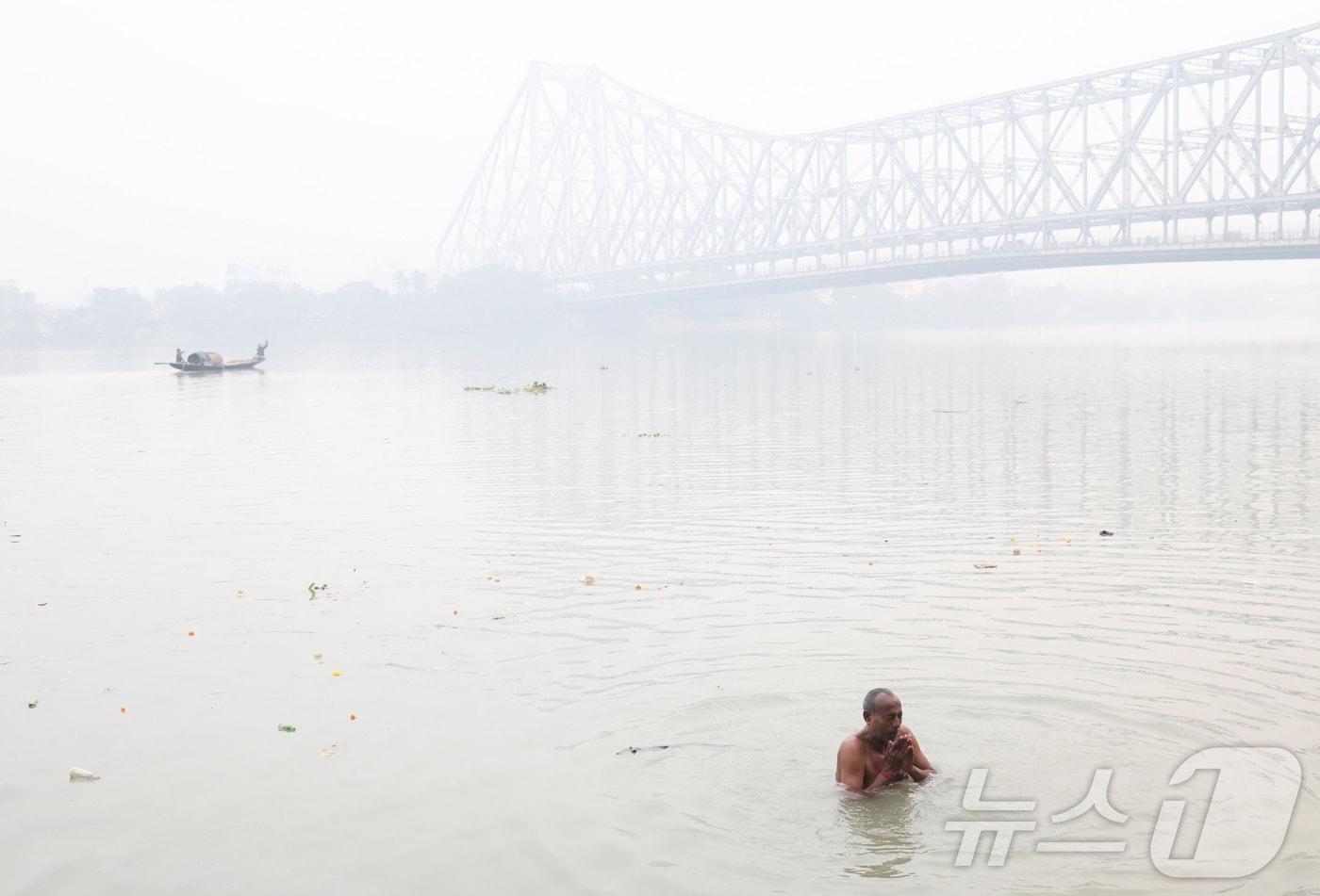 지난해 12월 8일 인도 콜카타 갠지스강 유역에서 한 남성이 강물에 몸을 담그고 기도를 하고 있 다. 2025.12.8 ⓒ 로이터=뉴스1 ⓒ News1 강민경 기자