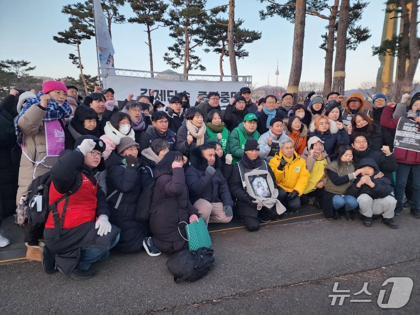 본문 이미지 - 2일 베트남 출신 이주민노동자 고(故) 뚜안 사망의 진상을 촉구하는 농성장 앞에서 유족과 시민단체, 시민들이 파이팅 포즈를 취하고 있다. 2026.01.02/ⓒ 뉴스1 권진영 기자