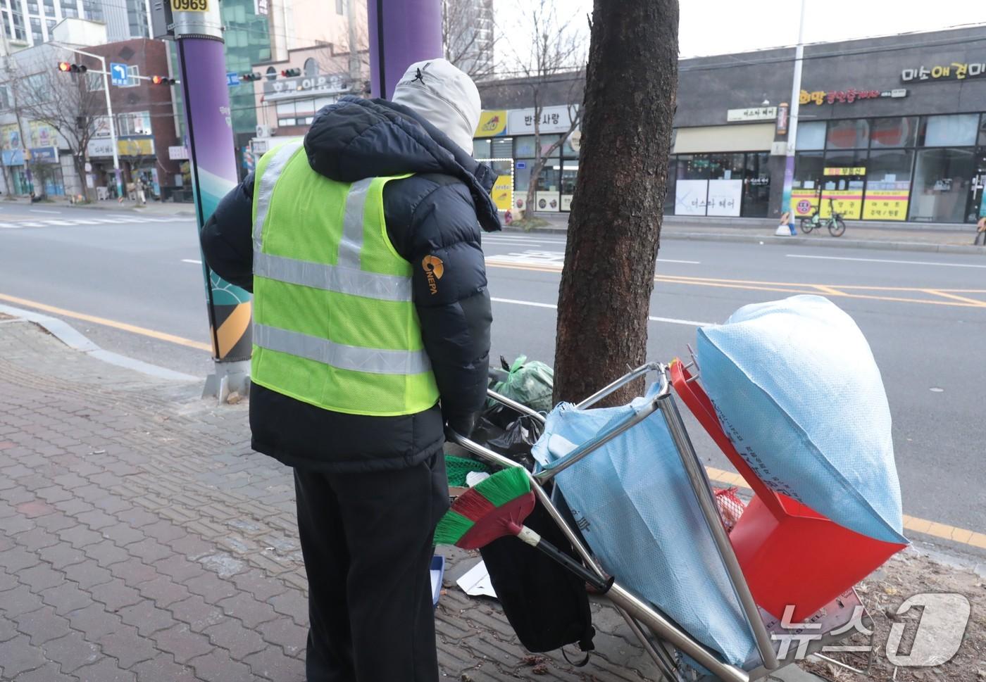 본문 이미지 - 아침 영하권 기온을 보인 20일 울산의 한 거리에서 형광 조끼를 입은 환경 공무직 근로자가 쓰레기를 줍고 있다.2026.1.20./뉴스1 ⓒ News1 김세은 기자
