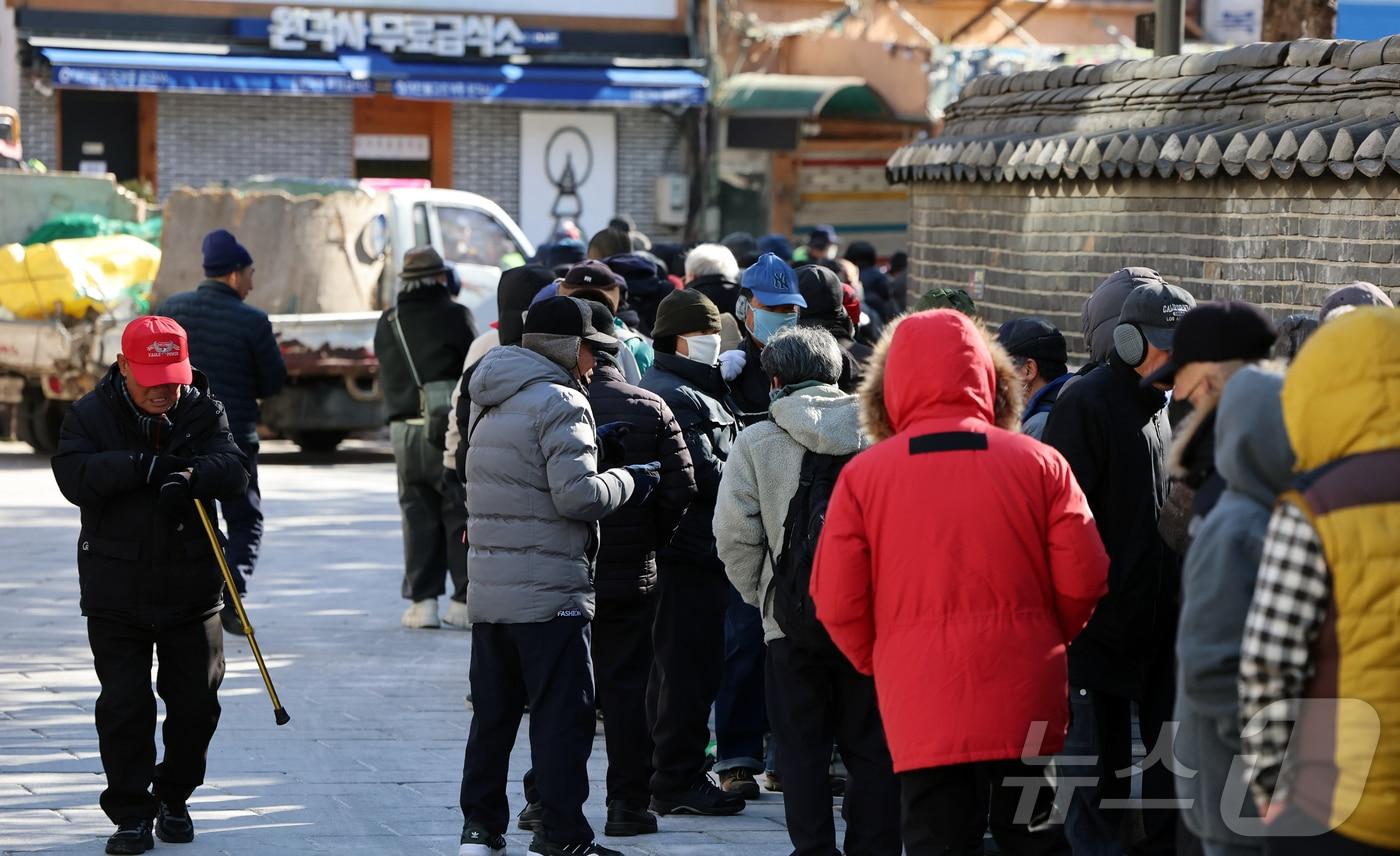 본문 이미지 - 서울 종로구 탑골공원 원각사 노인 무료급식소를 찾은 어르신들이 식사를 위해 줄을 서 있다. 2026.1.20/뉴스1 ⓒ News1 김진환 기자