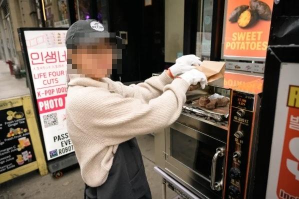 본문 이미지 - 뉴욕 코리아타운의 한 식당 앞에서 군고구마를 굽고 있는 여성. 출처=뉴욕포스트