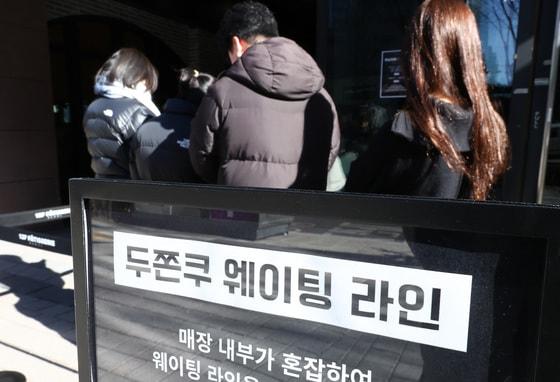 본문 이미지 - '두바이 쫀득 쿠키(두쫀쿠)' 열풍이 계속되는 20일 오후 서울 종로구 한 제과점에서 시민들이 두쫀쿠를 구매하기 위해 줄을 서 있다. 2026.1.20/뉴스1 ⓒ News1 최지환 기자