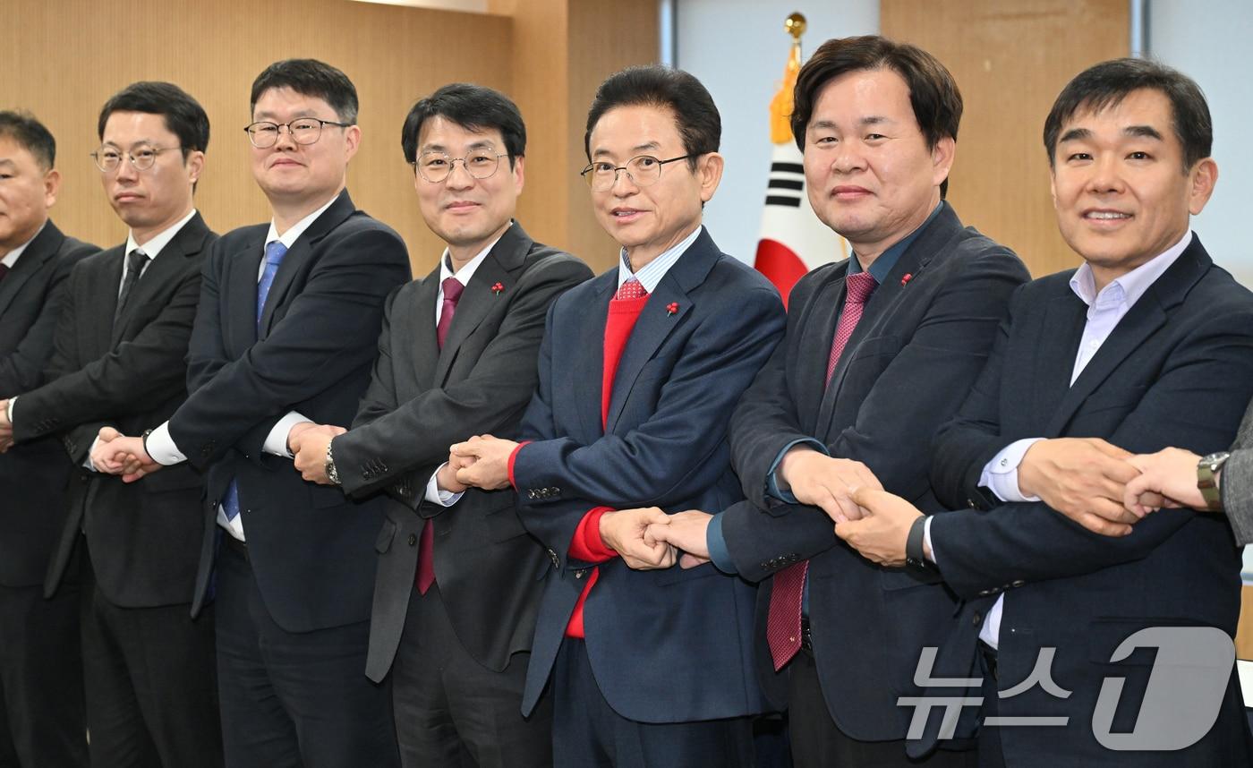 본문 이미지 - 이철우 경북지사와 김정기 대구시장 권한대행(행정부시장)을 비롯한 대구·경북 관계자들이 20일 오후 경북 안동시 경북도청에서 열린 대구·경북 행정통합 추진협의 회의에서 손을 잡고 있다. (경북도 제공. 재판매 및 DB 금지) 2026.1.20/뉴스1 ⓒ News1 공정식 기자