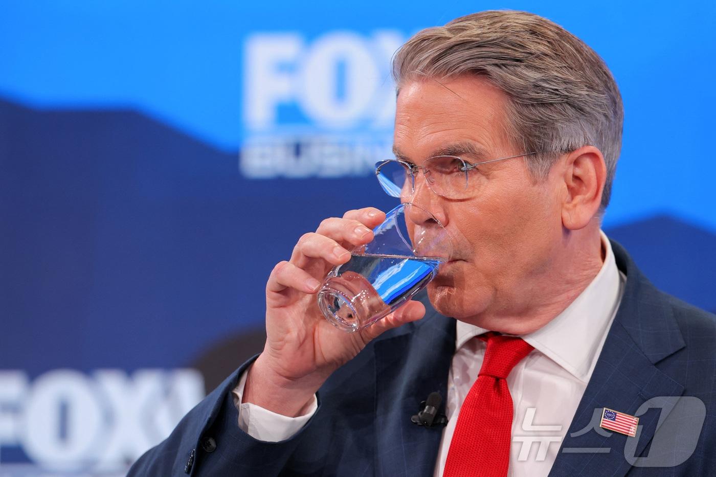 본문 이미지 - 스콧 베선트 미국 재무부 장관이 20일(현지시간) 스위스 다보스에서 열린 제56회 세계경제포럼(WEF)에 참석해 물을 마시고 있다. 2026.1.20 ⓒ 로이터=뉴스1 ⓒ News1 강민경 기자