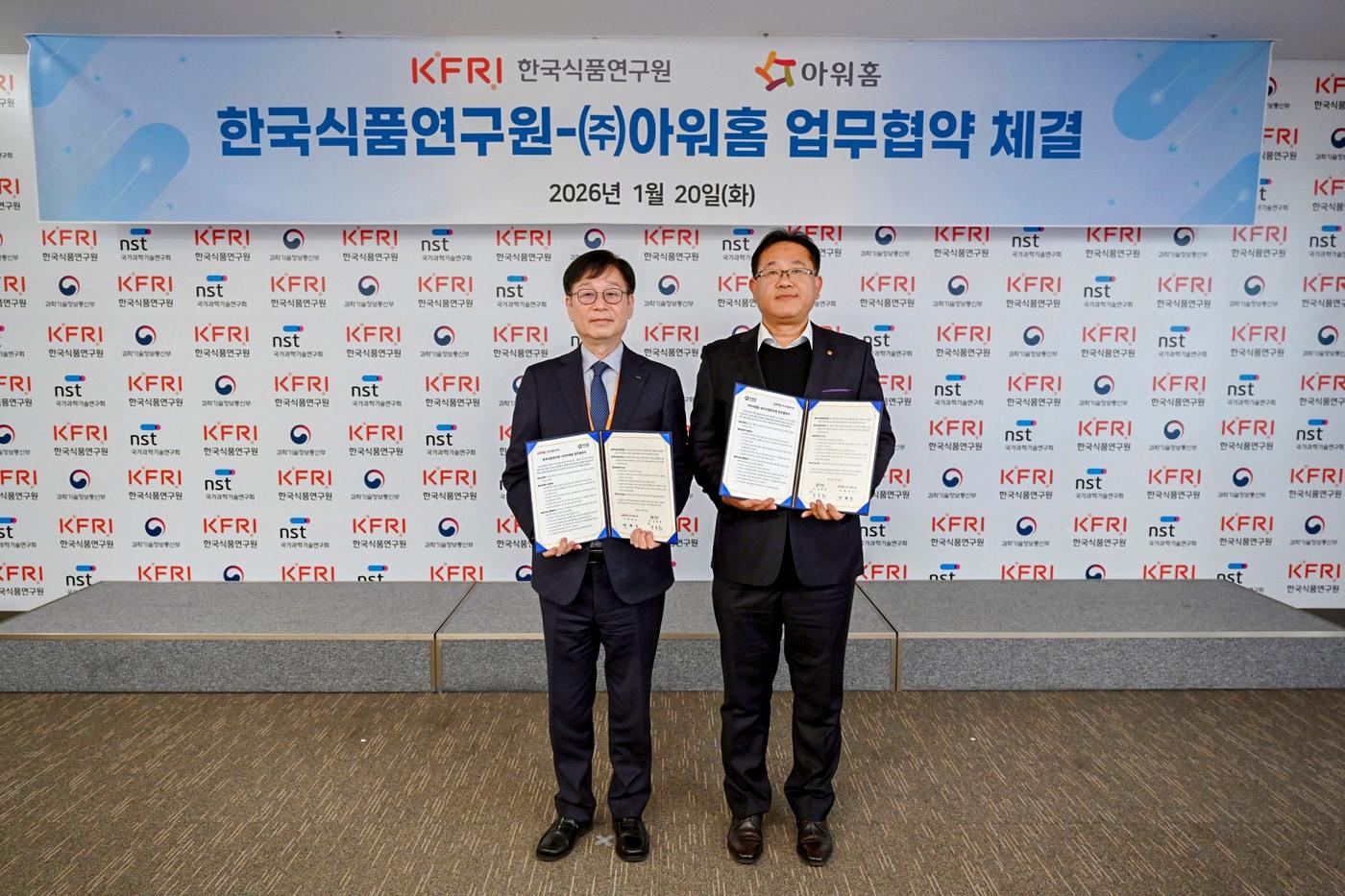 본문 이미지 -  20일 한국식품연구원에서 열린 아워홈-한국식품연구원 업무협약식에서 (왼쪽)백현동 한국식품연구원장과 양동운 아워홈 안전환경실장이  기념 촬영을 하는 모습.(아워홈 제공)