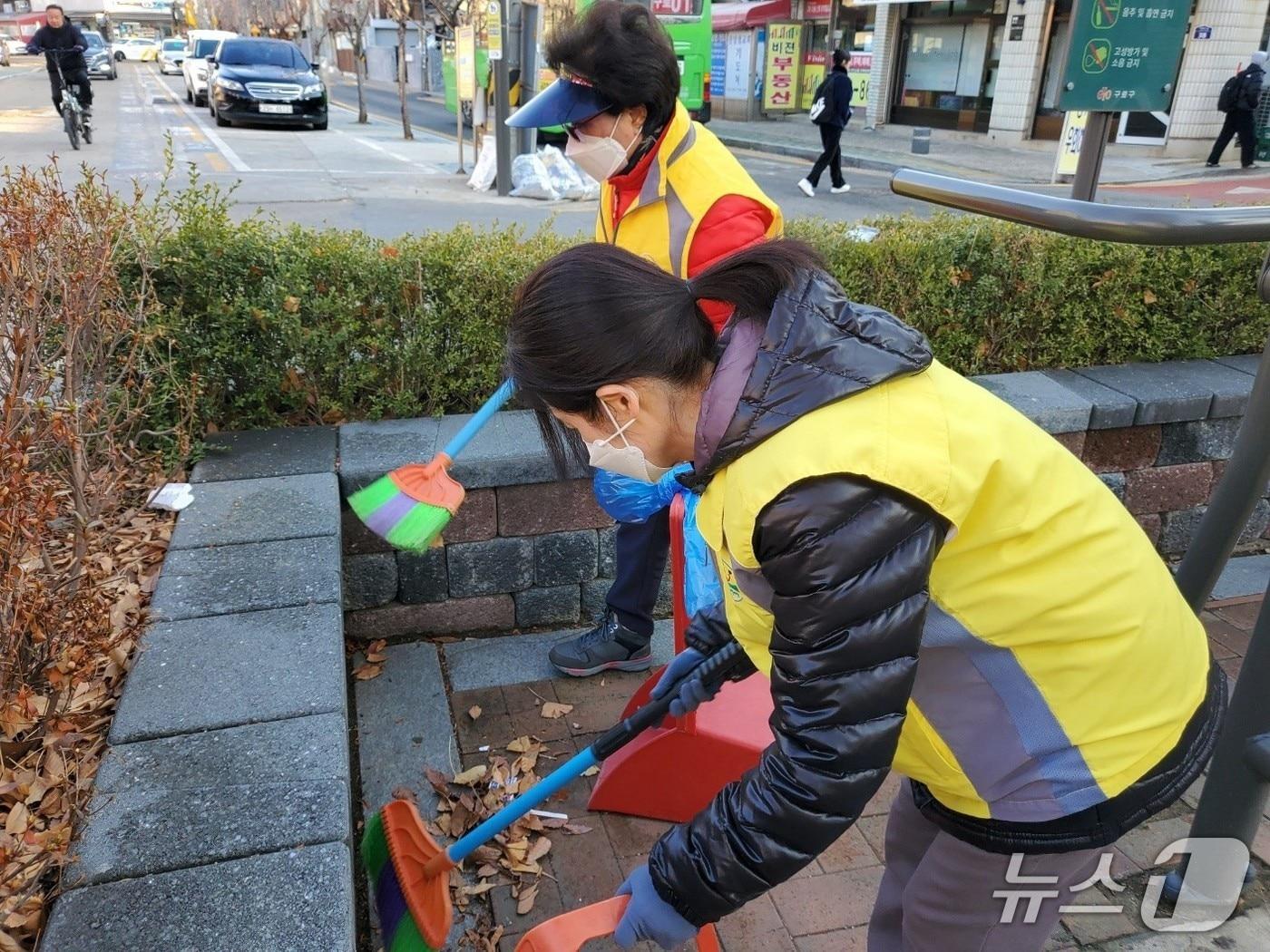 본문 이미지 - 환경순찰 스마트모니터요원들이 취약지점들을 순찰하며 청소를 하고 있다.(구로구 제공)