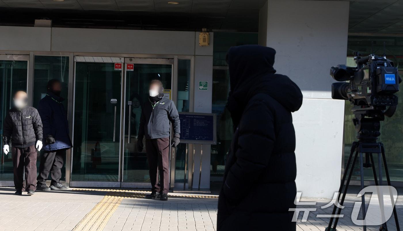 본문 이미지 - 21일 북한의 한국 무인기 침투 주장에 대한 진상을 규명하는 '군경합동조사 TF'가 민간인 피의자 3명에 대한 주거지 및 사무실 등에 대해 항공안전법 위반 혐의로 압수수색영장을 집행하고 있다. 사진은 이날 사무실로 알려진 서울시내 한 대학교 앞 취재진 모습. 2026.1.21/뉴스1 ⓒ News1 김명섭 기자
