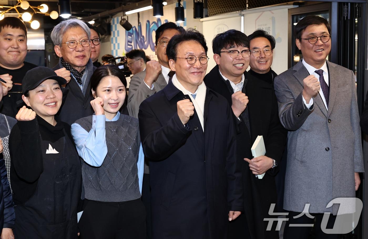 본문 이미지 - 김민석 국무총리가 21일 오후 서울 동대문구 경동시장 청년몰을 찾아 청년 창업자들과 함께 기념촬영을 하고 있다. 2026.1.21/뉴스1 ⓒ News1 구윤성 기자