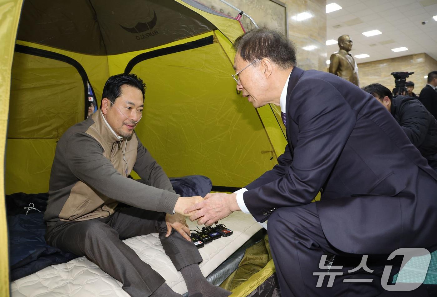 본문 이미지 - 단식 중인 장동혁 국민의힘 대표가 21일 서울 여의도 국회 로텐더홀 단식 농성장을 찾은 이석연 국민통합위원장과 인사하고 있다. (공동취재) 2026.1.21/뉴스1 ⓒ News1 신웅수 기자