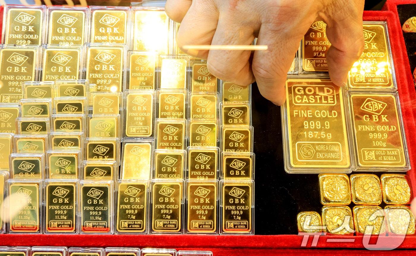 본문 이미지 - 도널드 트럼프 미국 대통령이 그린란드 확보를 위해 유럽 국가들에 대한 추가 관세 부과를 시사하자 금과 은 가격이 사상 최고 수준으로 치솟은 21일 서울 종로구 한 금은방에서 직원이 골드바를 정리하고 있다. 2026.1.21/뉴스1 ⓒ News1 이호윤 기자