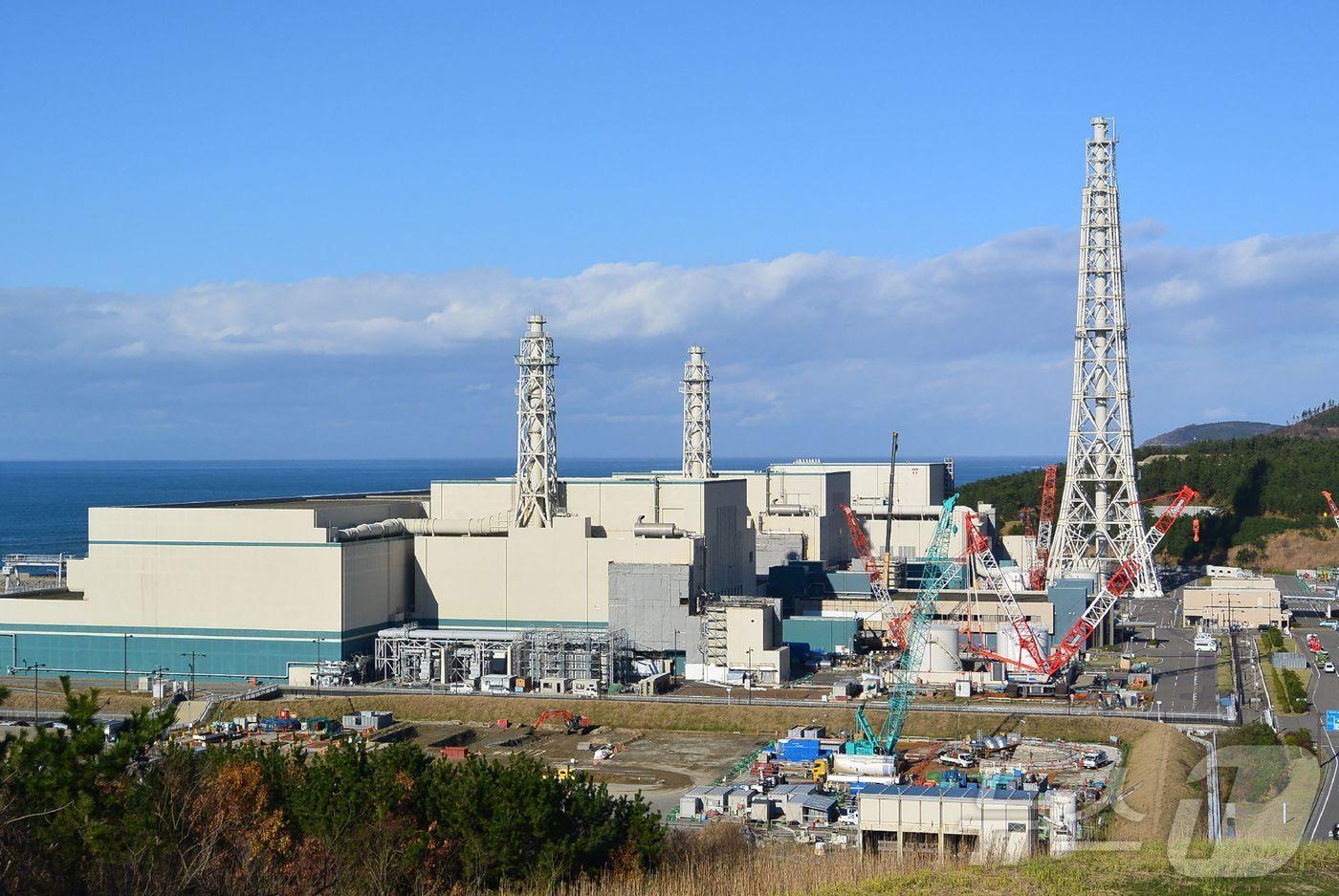 본문 이미지 - 2015년 12월 7일 촬영된 사진으로, 일본 니가타현 가시와자키시에 위치한 도쿄전력 가시와자키가리와 원자력발전소 6·7호기(앞쪽부터 7호기와 6호기)가 보인다. 세계 최대 규모의 이 원자력발전소는 2011년 후쿠시마 원전 사고 이후 처음으로 2026년 1월 21일 재가동될 예정이다.2015.12.07.ⓒ AFP=뉴스1