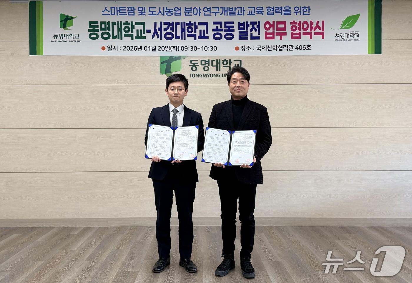 본문 이미지 - 20일 부산 남구 동명대학교에서 열린 동명대-서경대 공동 발전 업무 협약식에서 차지철 동명대 기획처장(왼쪽)과 이석형 서경대 미래전략·예산처장이 협약서를 들어 보이고 있다. (동명대 제공. 재판매 및 DB 금지)