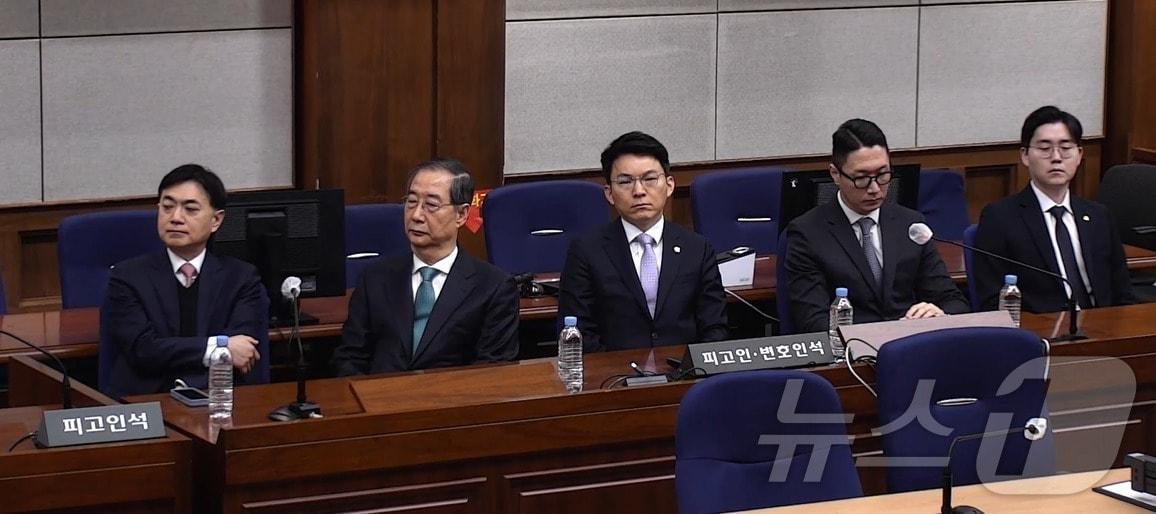 본문 이미지 - 한덕수 전 국무총리가 21일 서울 서초구 서울중앙지방법원에서 열린 내란 우두머리 방조, 내란 중요임무 종사 혐의 사건 1심 선고공판에 출석, 이진관 부장판사가 징역 23년형을 선고하는 모습을 지켜보고 있다. (서울중앙지방법원 제공 영상 캡쳐. 재판매 및 DB 금지) 2026.1.21/뉴스1