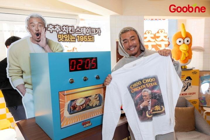 본문 이미지 - 추성훈과 굽네치킨 공식 서포터즈 '굽러버'가 굽네 플레이타운 앞에서 기념촬영을 하고 있다.(지앤푸드 제공)