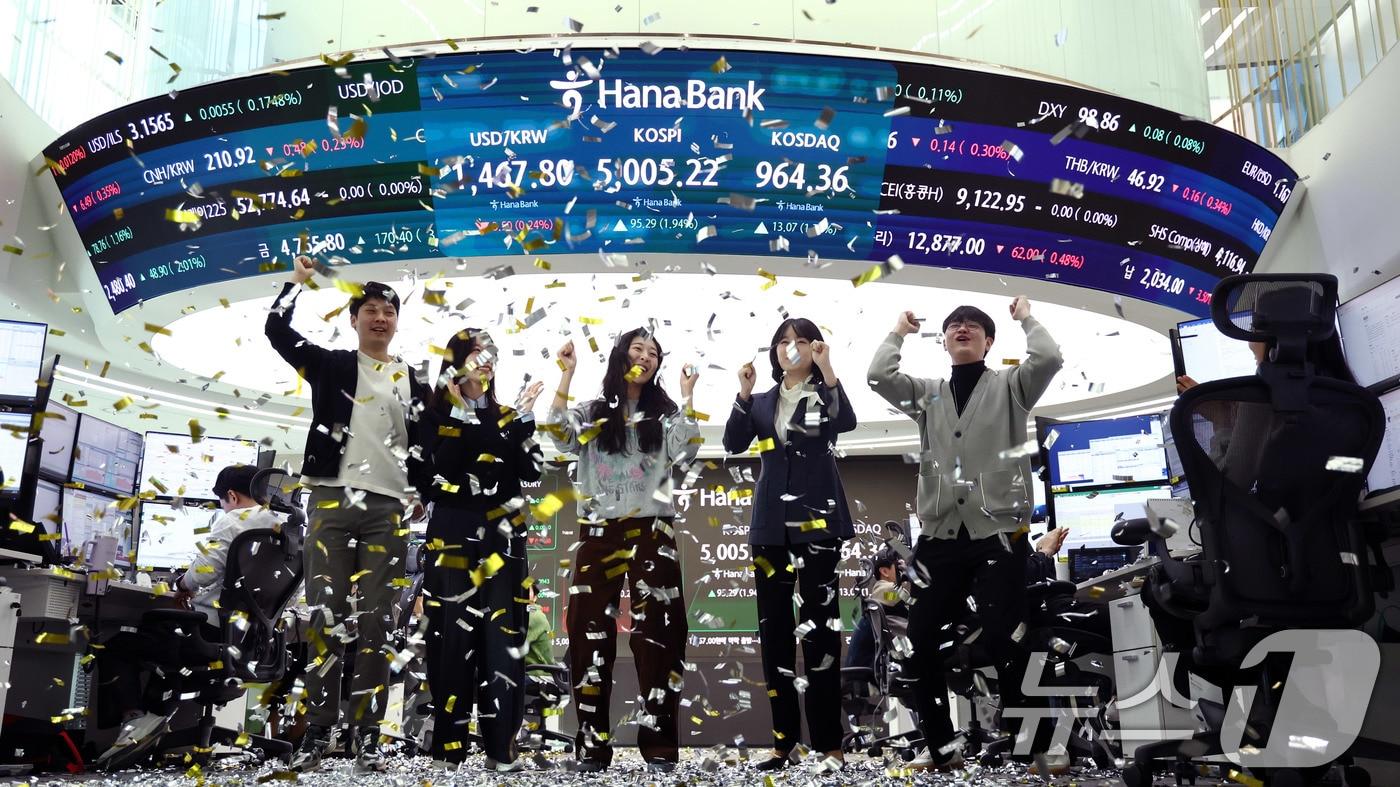 본문 이미지 - 22일 오전 서울 중구 하나은행 본점 딜링룸 현황판에 코스피 지수가 장중 5000p를 넘으며 개장하자 직원들이 환호하고 있다. ⓒ News1 박지혜 기자