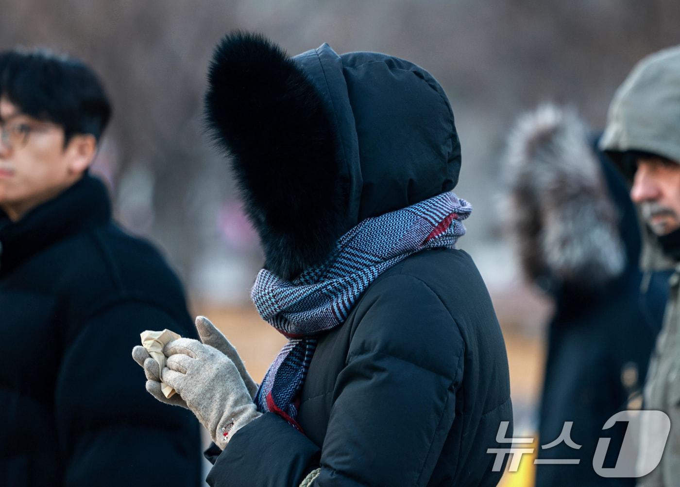 본문 이미지 - 지난 22일 서울 종로구 세종대로사거리에서 두터운 옷차림의 시민이 손난로에 손을 녹이고 있다. 2026.1.22/뉴스1 ⓒ News1 이호윤 기자