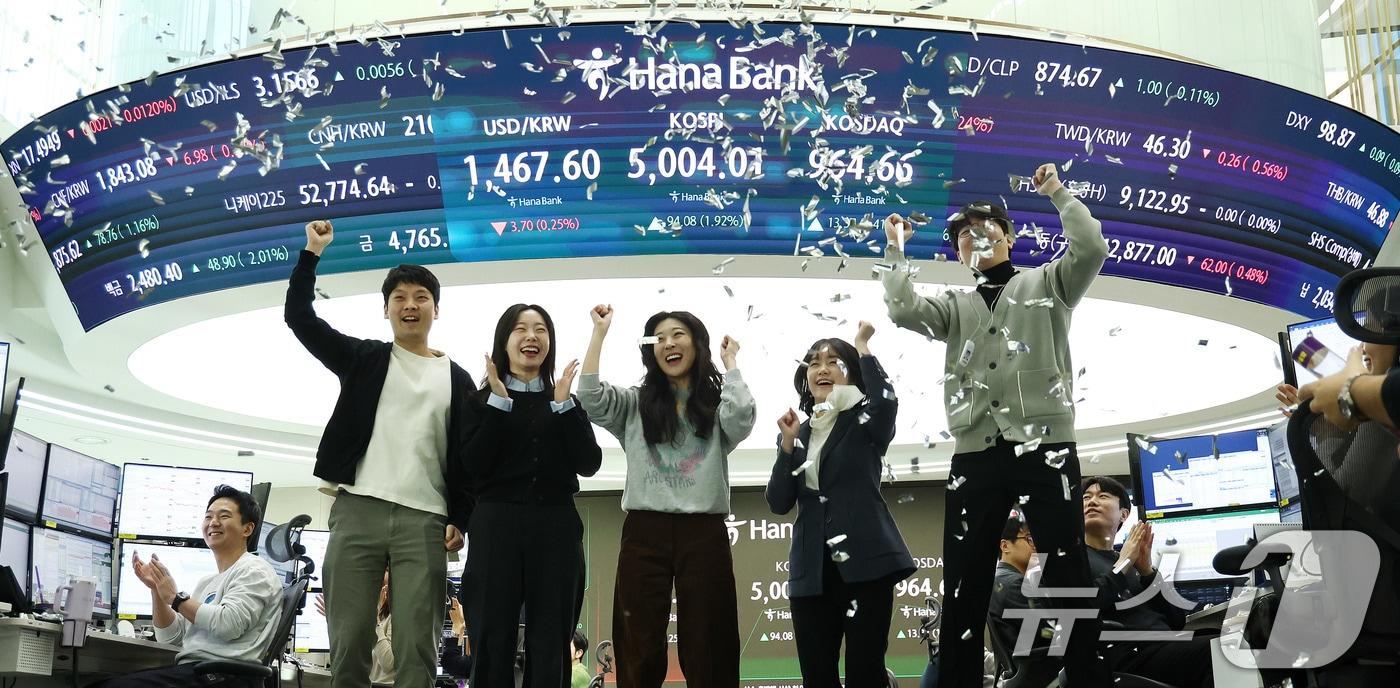 본문 이미지 - 22일 오전 서울 중구 하나은행 본점 딜링룸 현황판에 코스피 지수가 장중 5000p를 넘으며 개장하자 직원들이 환호하고 있다. 2026.1.22/뉴스1 ⓒ News1 박지혜 기자